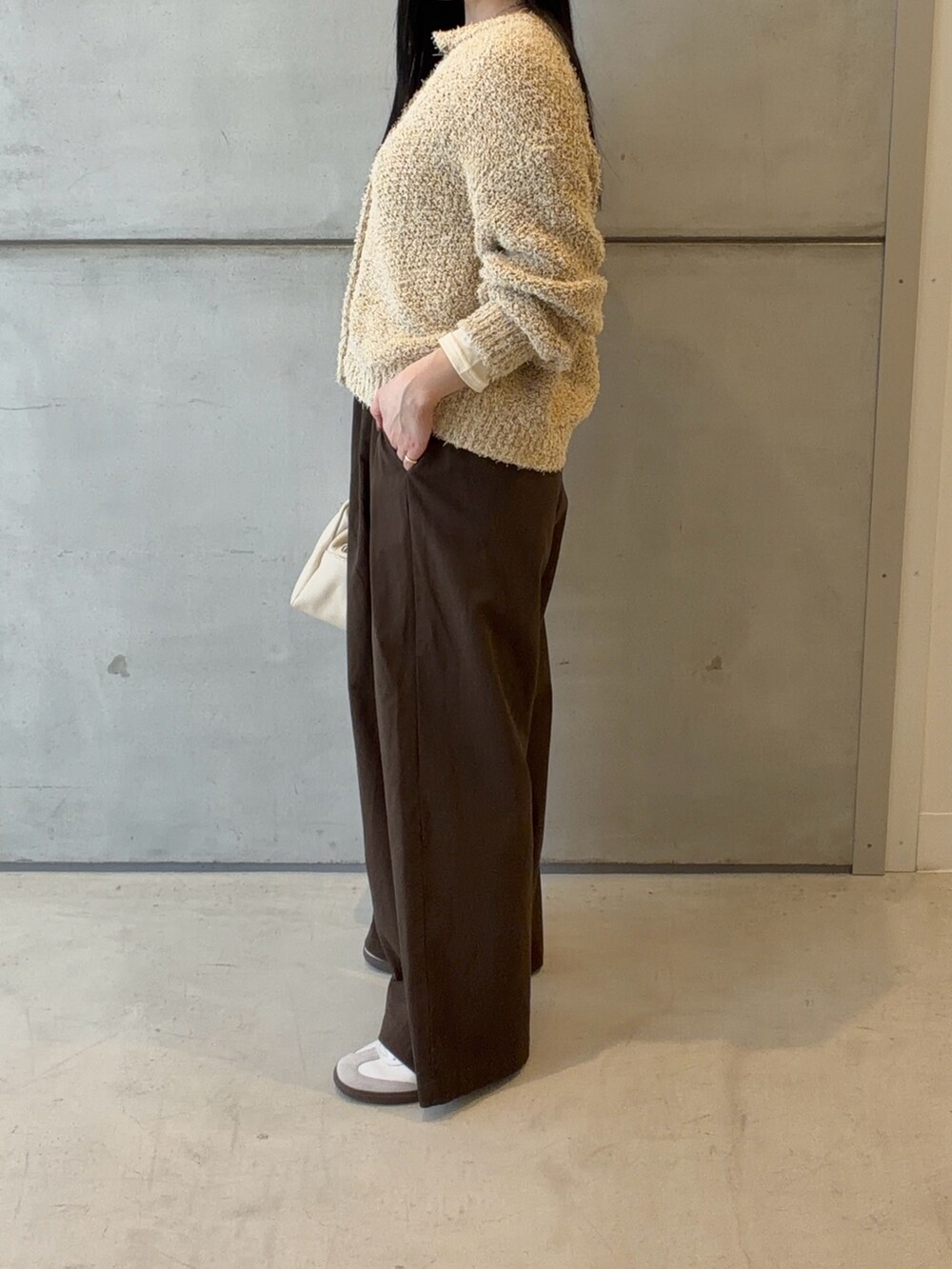 イエロー系のカーディガン/ボレロ、ホワイト系のTシャツ/カットソー、ホワイト系のハンドバッグを着用したレディースの春コーディネートの2枚目の写真