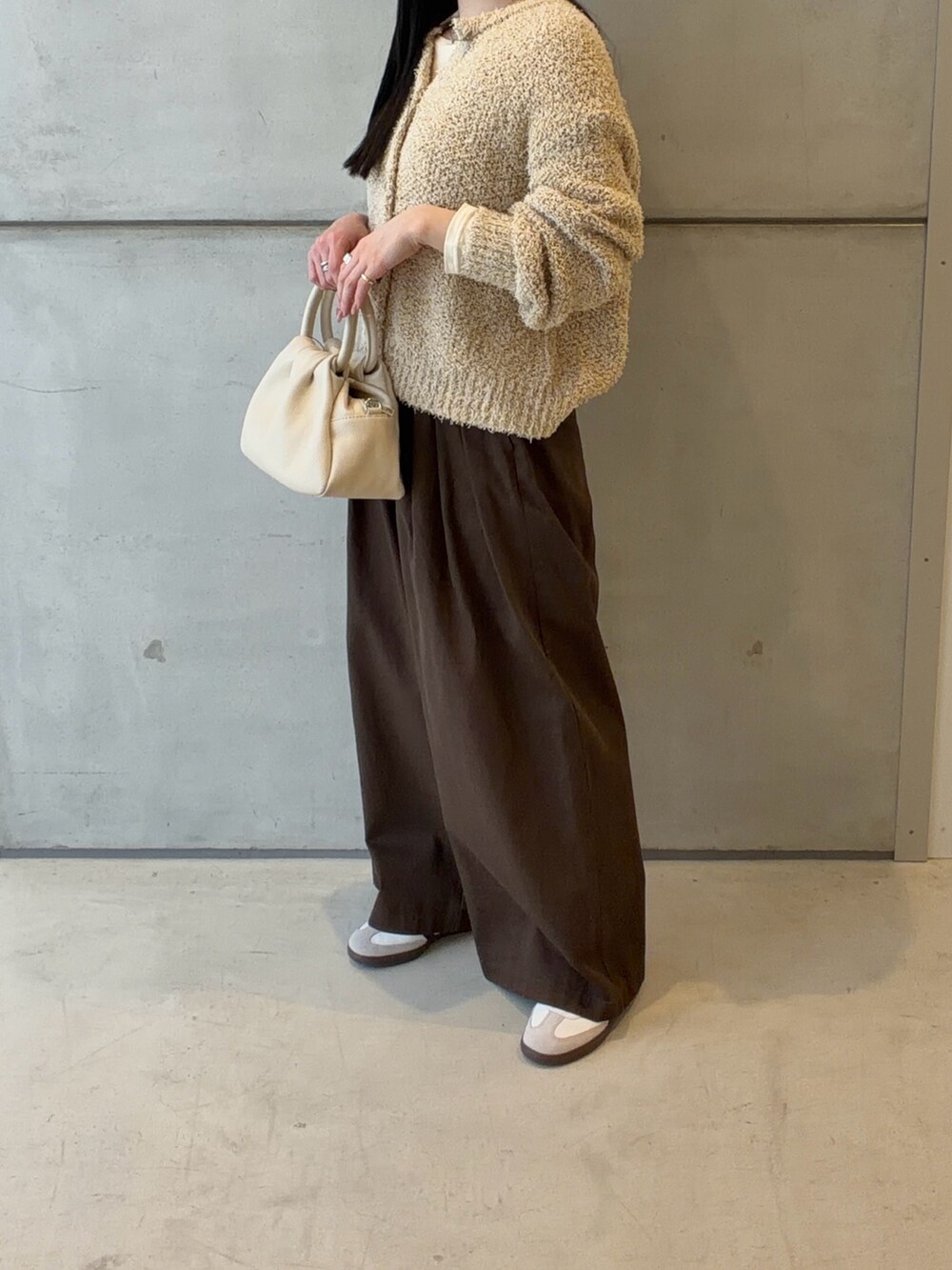 イエロー系のカーディガン/ボレロ、ホワイト系のTシャツ/カットソー、ホワイト系のハンドバッグを着用したレディースの春コーディネートの4枚目の写真