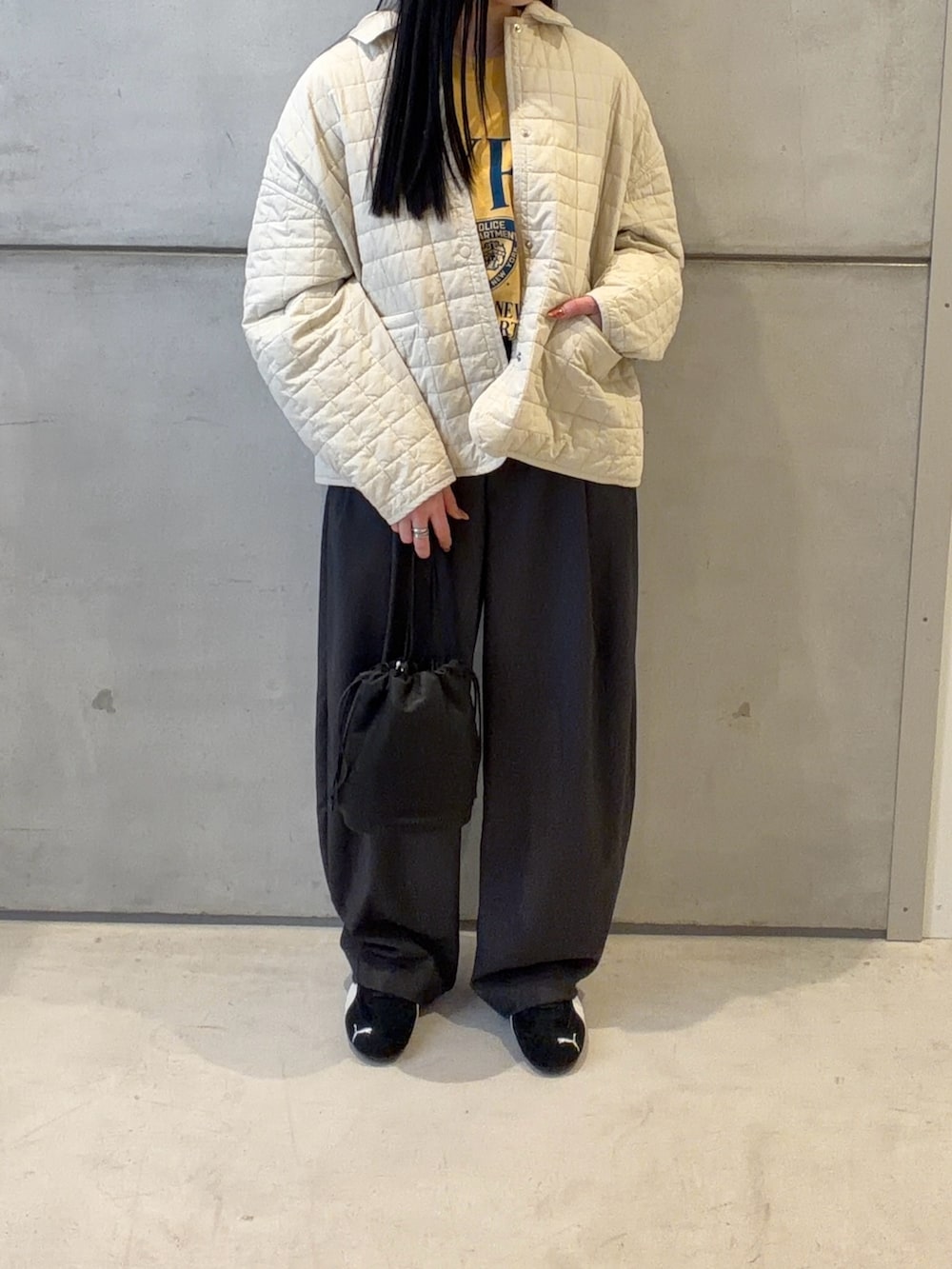 ホワイト系のダウンジャケット/コート、グレー系のその他パンツ、ブラック系のショルダーバッグを着用したレディースの春コーディネートの4枚目の写真