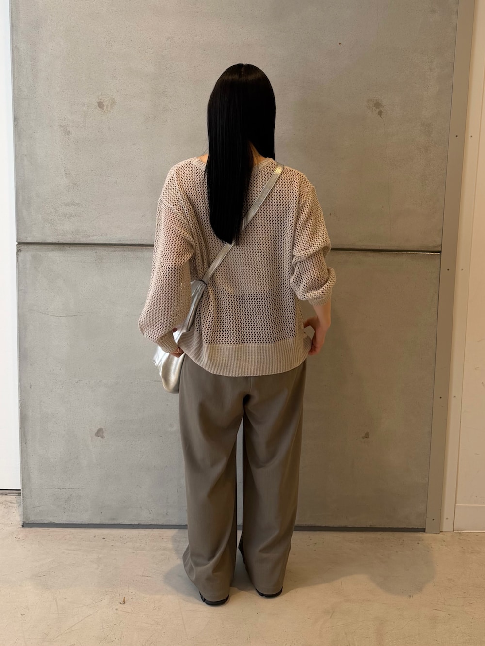 グレー系のニット/セーター、グレー系のその他パンツ、ブラック系のスニーカーを着用したレディースの春コーディネートの3枚目の写真