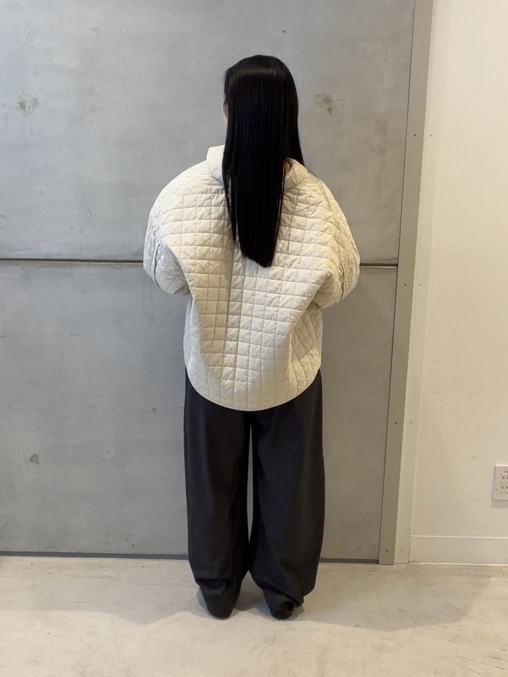 ホワイト系のダウンジャケット/コート、グレー系のその他パンツ、ブラック系のショルダーバッグを着用したレディースの春コーディネートの2枚目の写真