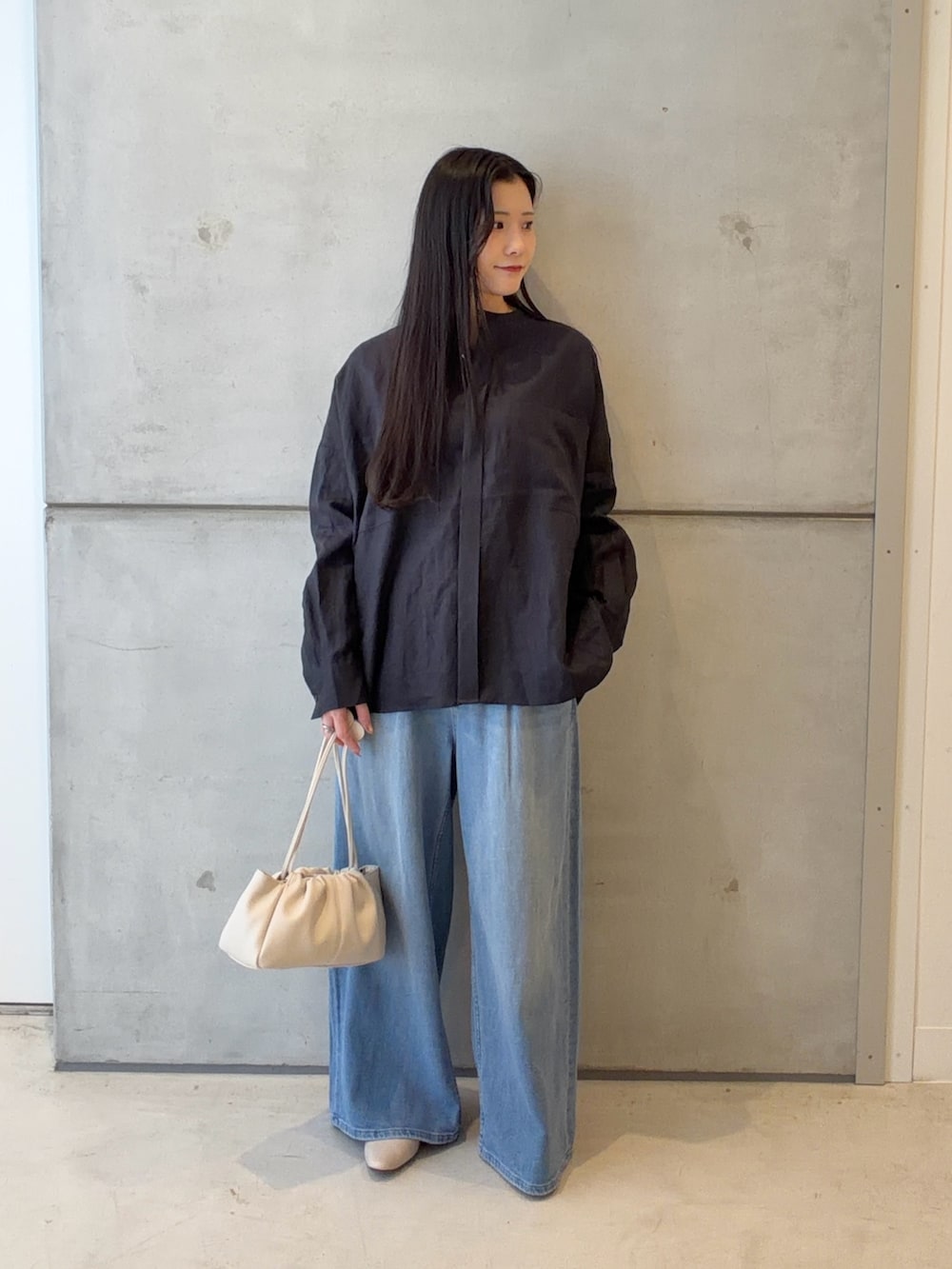 ブルー系のシャツ/ブラウス、ブルー系のデニムパンツ、ホワイト系のショルダーバッグを着用したレディースの春コーディネートの2枚目の写真