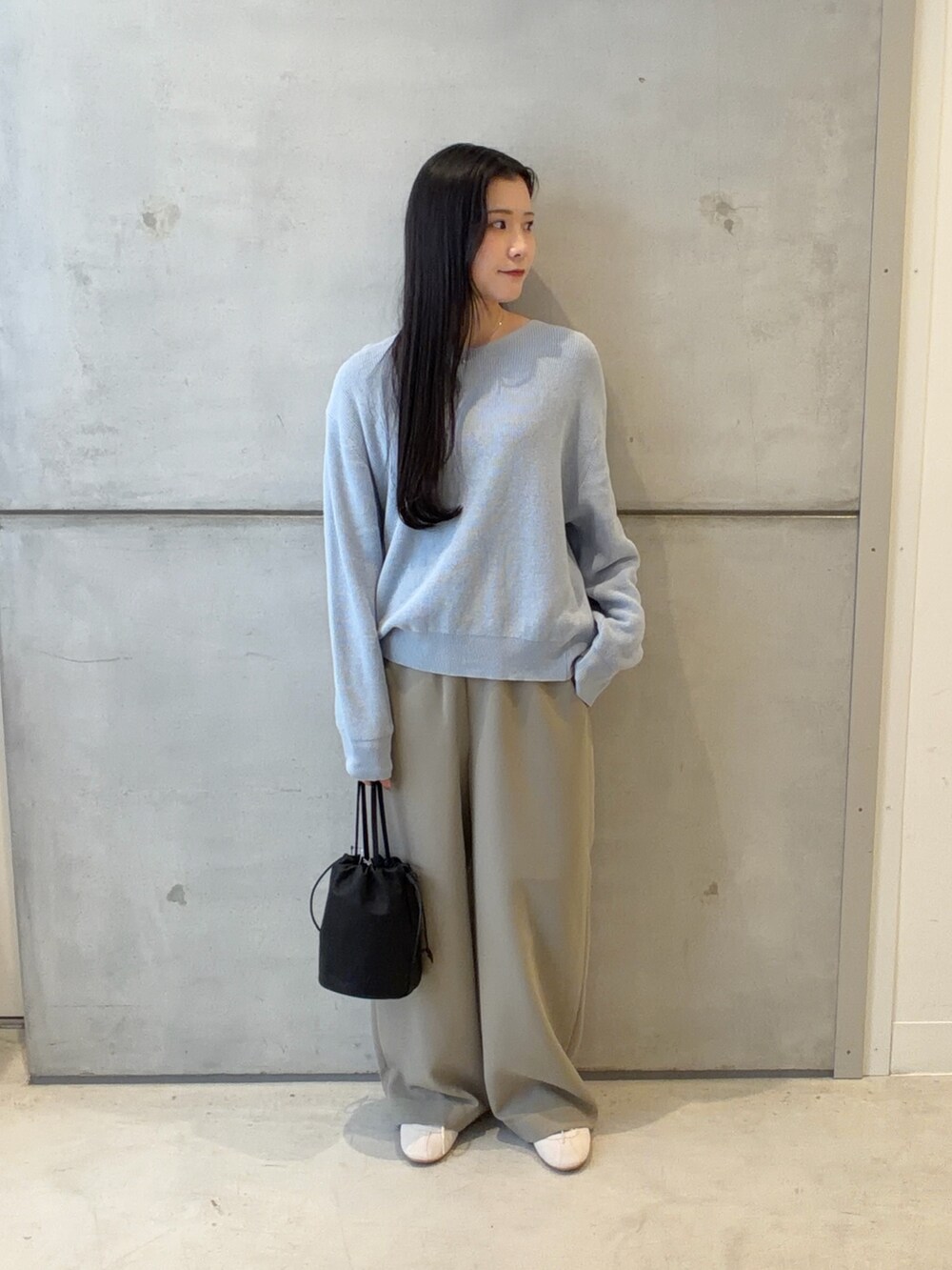 ブルー系のニット/セーター、ベージュ系のその他パンツ、ホワイト系のスニーカーを着用したレディースの春コーディネートの2枚目の写真