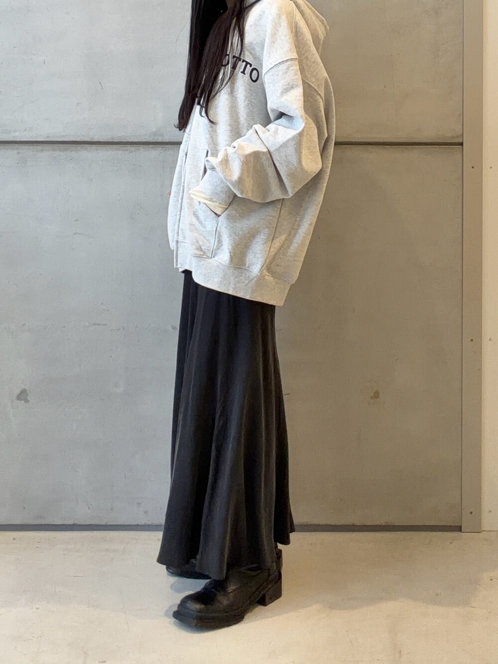 グレー系のパーカー、グレー系のスカートを着用したレディースの春コーディネートの2枚目の写真
