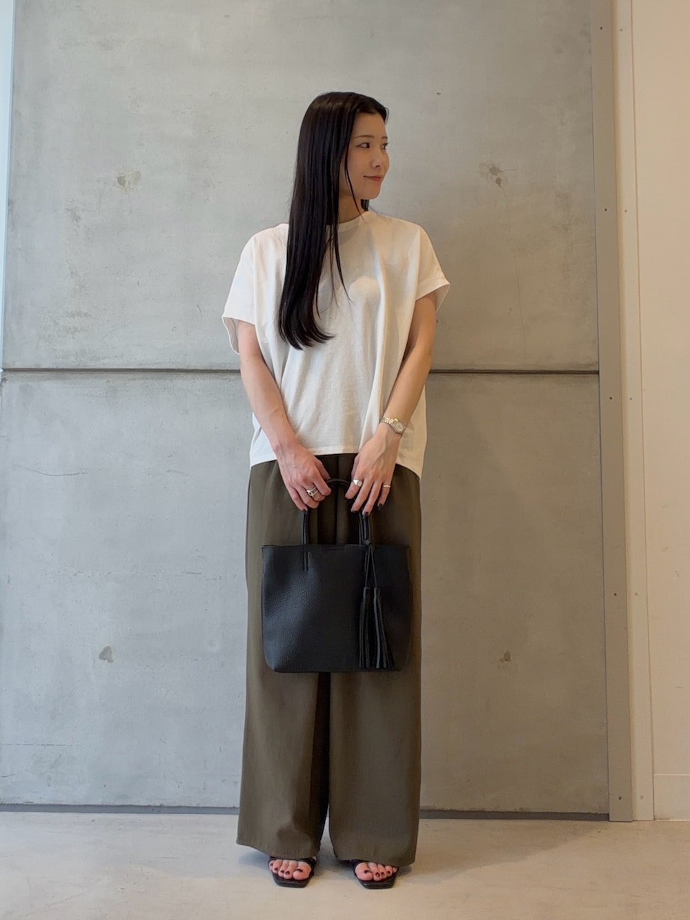 ホワイト系のTシャツ/カットソー、グリーン系のその他パンツ、ブラック系のトートバッグを着用したレディースの夏コーディネートの2枚目の写真
