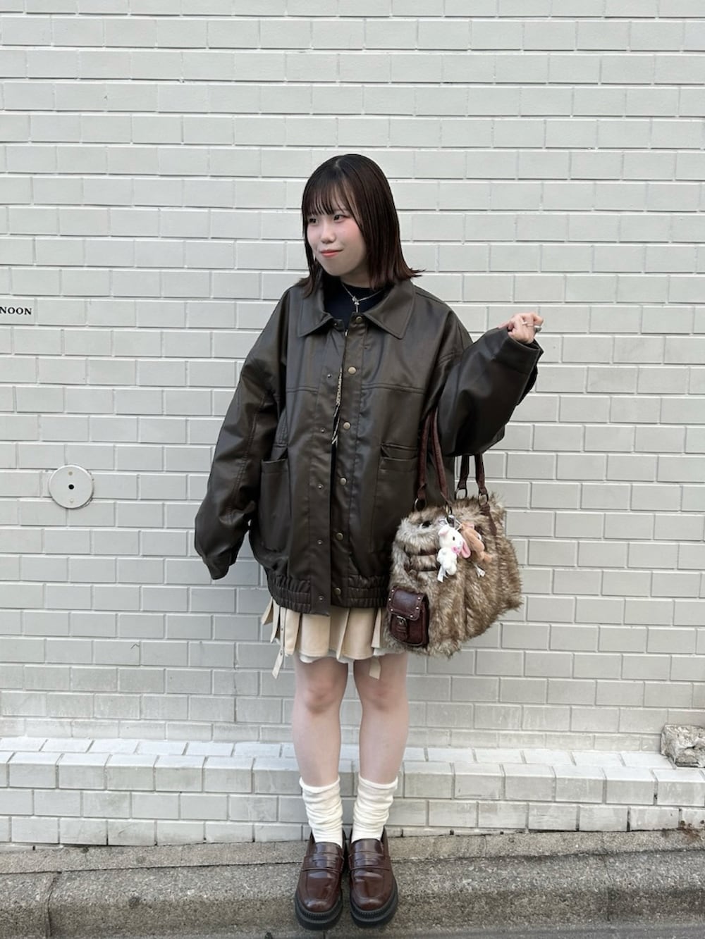 ブルー系のスウェット、ベージュ系のスカート、ブラウン系のブルゾンを着用したレディースの冬コーディネートの2枚目の写真