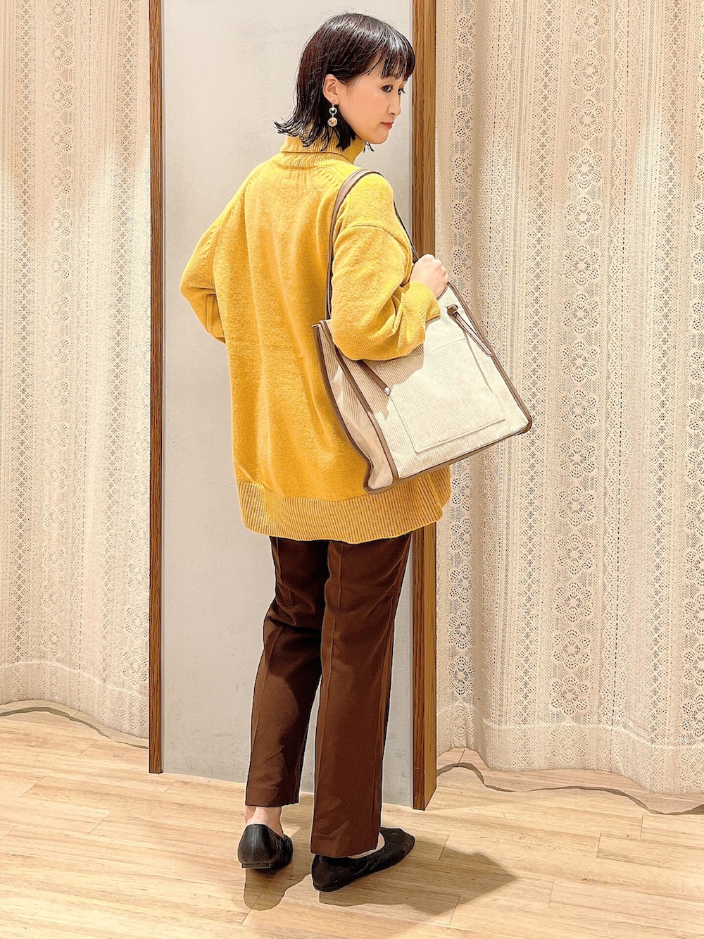 ブラック系のパンプス、ベージュ系のトートバッグ、ブラウン系のその他パンツを着用したレディースの冬コーディネートの2枚目の写真