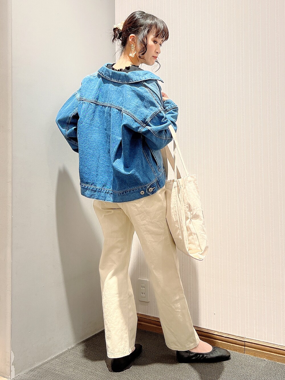 ブラック系のパンプス、ブルー系のデニムパンツ、ブルー系のデニムジャケットを着用したレディースの春コーディネートの3枚目の写真