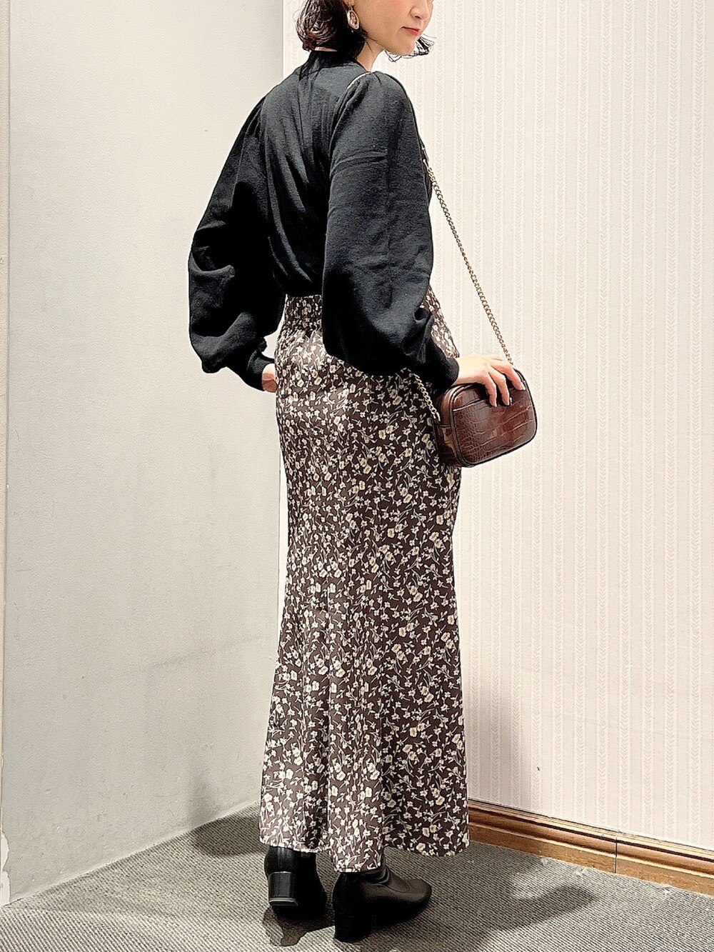 ブラック系のブーツ、ブラウン系のスカート、ブラウン系のショルダーバッグを着用したレディースの冬コーディネートの3枚目の写真