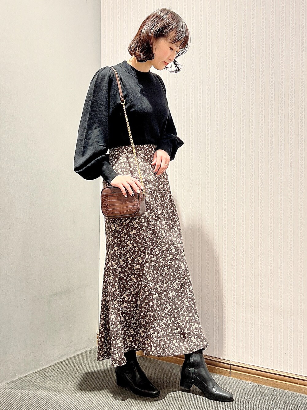 ブラック系のブーツ、ブラウン系のスカート、ブラウン系のショルダーバッグを着用したレディースの冬コーディネートの2枚目の写真