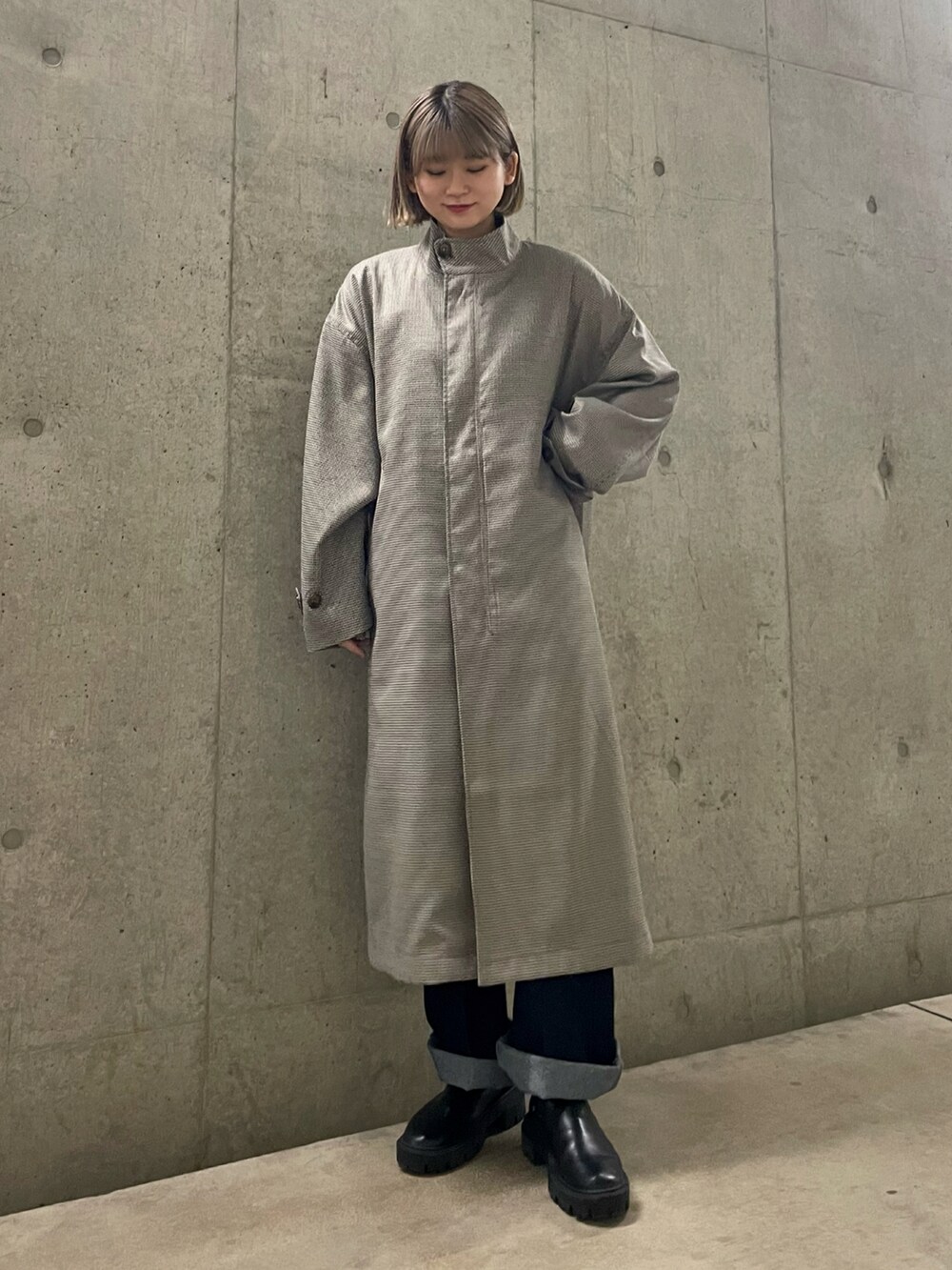 ホワイト系のニット/セーター、ベージュ系のモッズコート、ブラック系のデニムパンツを着用したレディースの春コーディネートの2枚目の写真