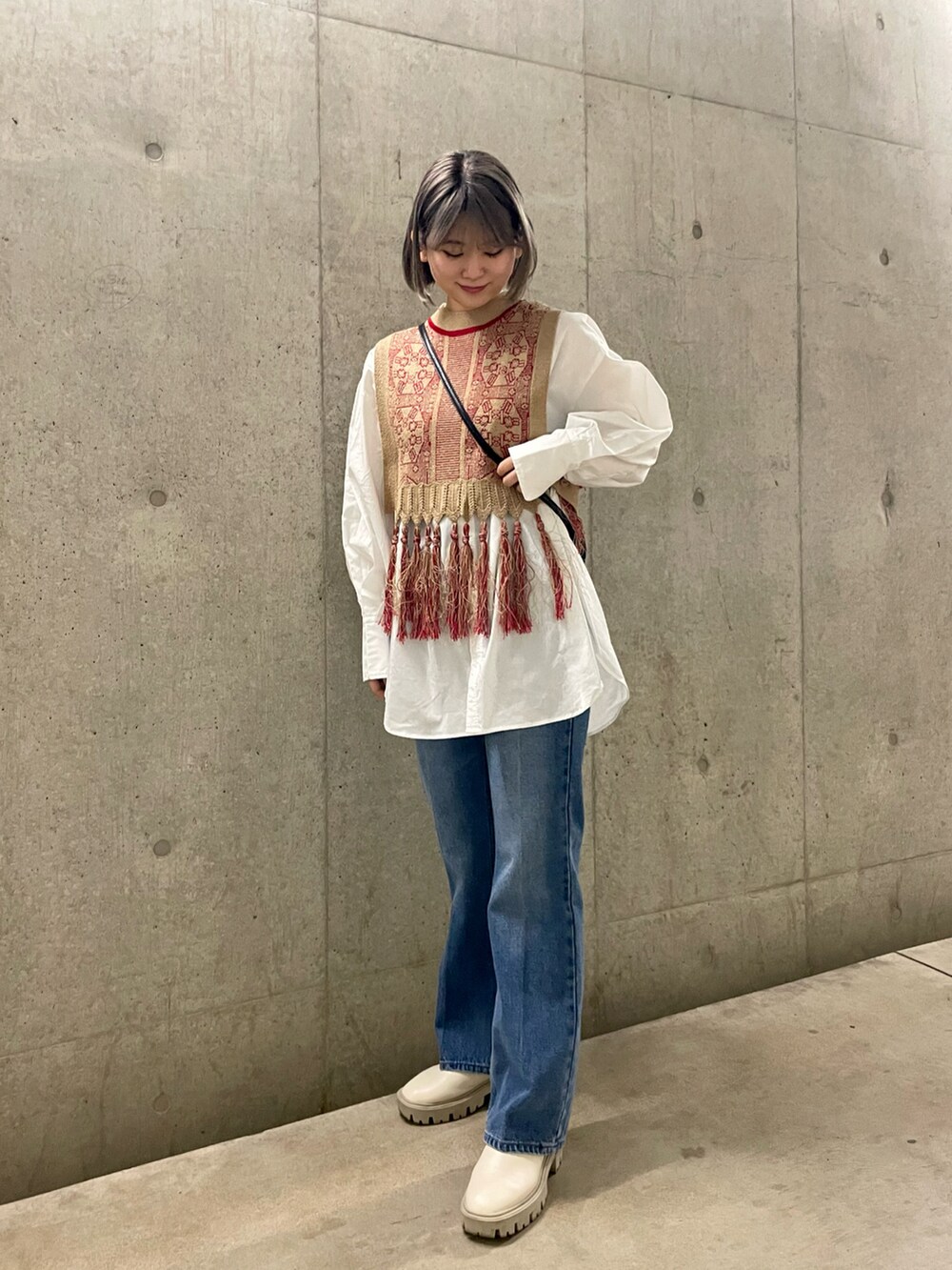 ブラック系のショルダーバッグ、レッド系のベスト、ホワイト系のシャツ/ブラウスを着用したレディースの春コーディネートの2枚目の写真