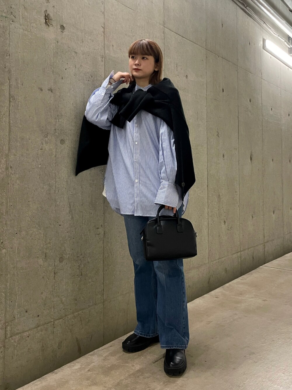ブラック系のカーディガン/ボレロ、ブルー系のシャツ/ブラウス、ブルー系のデニムパンツを着用したレディースの冬コーディネートの2枚目の写真