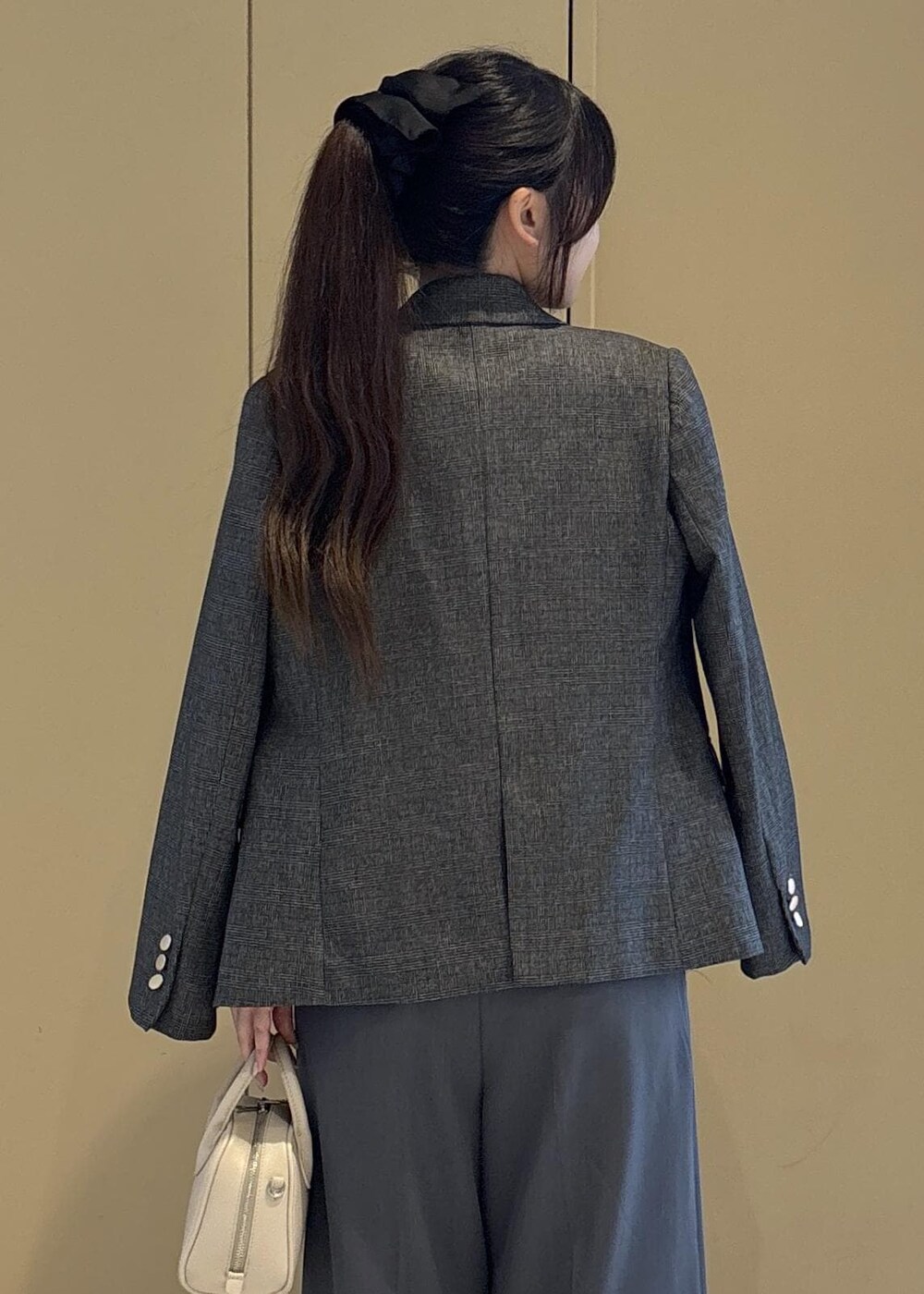 グレー系のテーラードジャケット、ホワイト系のニット/セーター、グレー系のその他パンツを着用したレディースの秋コーディネートの6枚目の写真