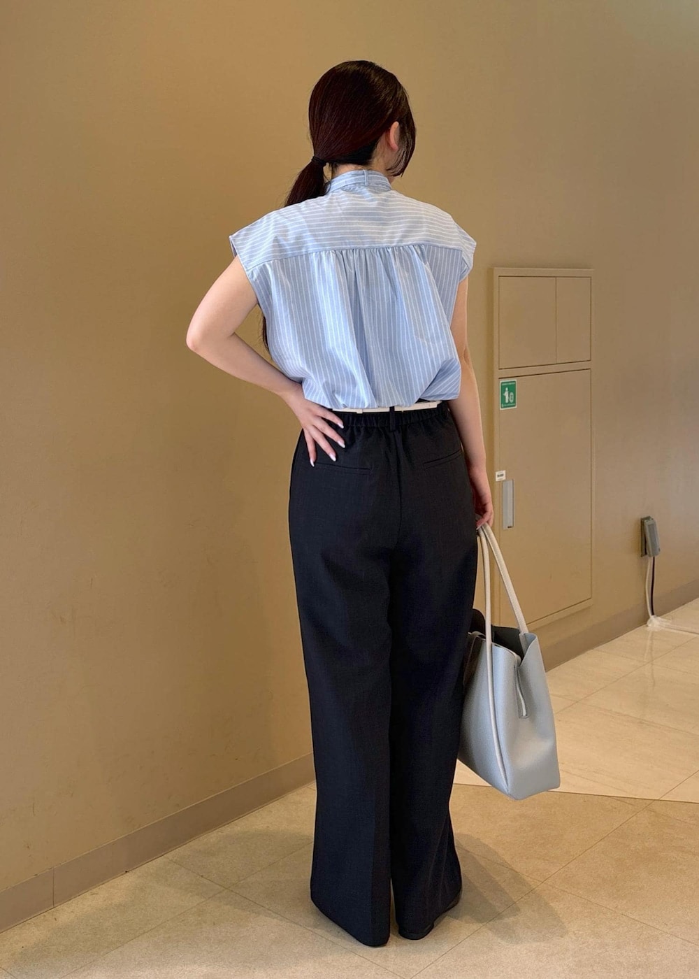 ブルー系のシャツ/ブラウス、グレー系のその他パンツ、ブラック系のローファーを着用したレディースの夏コーディネートの3枚目の写真