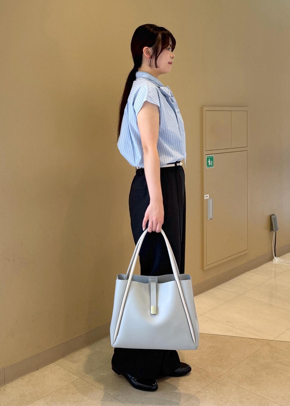 ブルー系のシャツ/ブラウス、グレー系のその他パンツ、ブラック系のローファーを着用したレディースの夏コーディネートの2枚目の写真