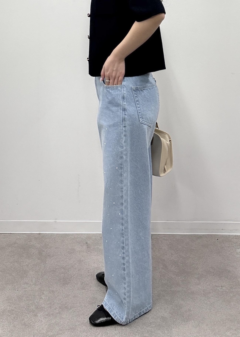 ホワイト系のボストンバッグ、ブルー系のデニムパンツ、ブルー系のカーディガン/ボレロを着用したレディースの春コーディネートの8枚目の写真