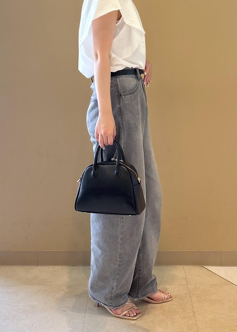 ホワイト系のシャツ/ブラウス、ゴールド系のサンダル、グレー系のデニムパンツを着用したレディースの夏コーディネートの8枚目の写真