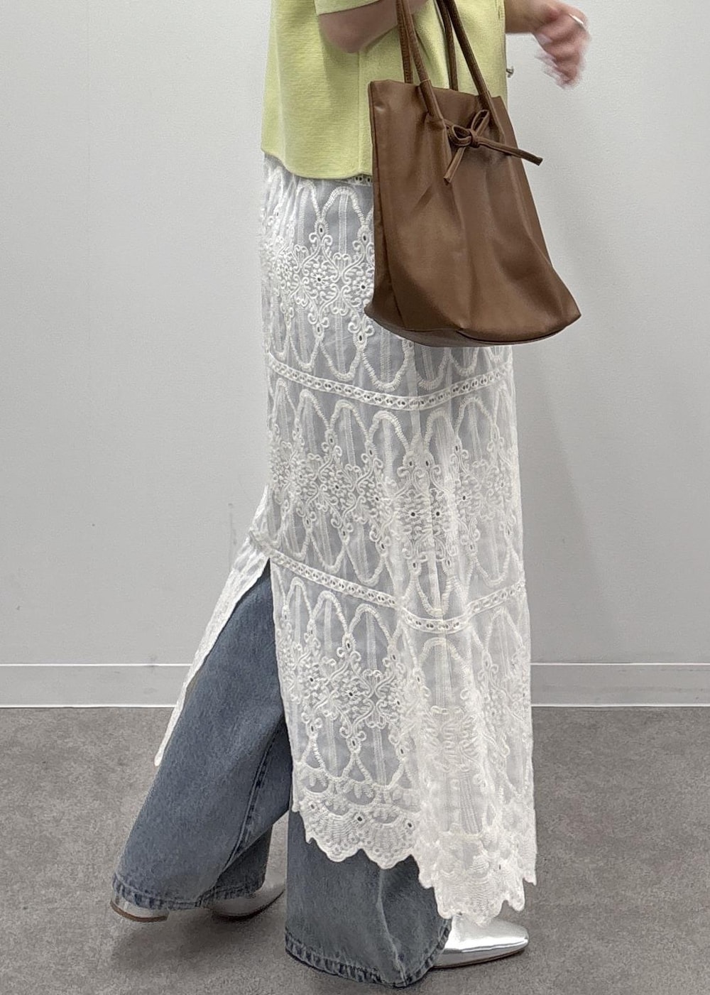 ホワイト系のワンピース、ブラウン系のタンクトップ、グリーン系のカーディガン/ボレロを着用したレディースの春コーディネートの8枚目の写真