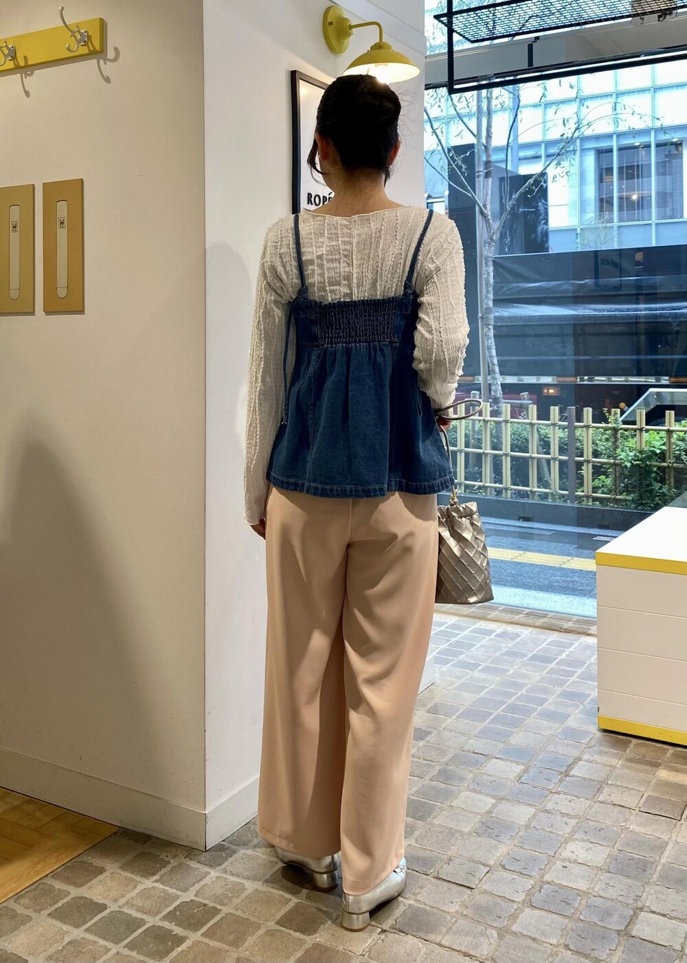 シルバー系のパンプス、ホワイト系のTシャツ/カットソー、シルバー系のショルダーバッグを着用したレディースの春コーディネートの2枚目の写真