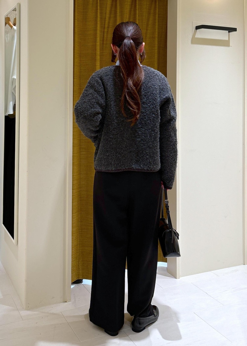 ブラック系のその他パンツ、ブラック系のショルダーバッグ、グレー系のブルゾンを着用したレディースの冬コーディネートの3枚目の写真