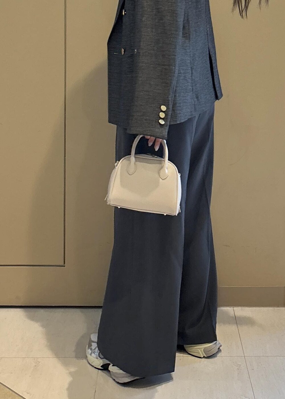 グレー系のテーラードジャケット、ホワイト系のニット/セーター、グレー系のその他パンツを着用したレディースの秋コーディネートの8枚目の写真