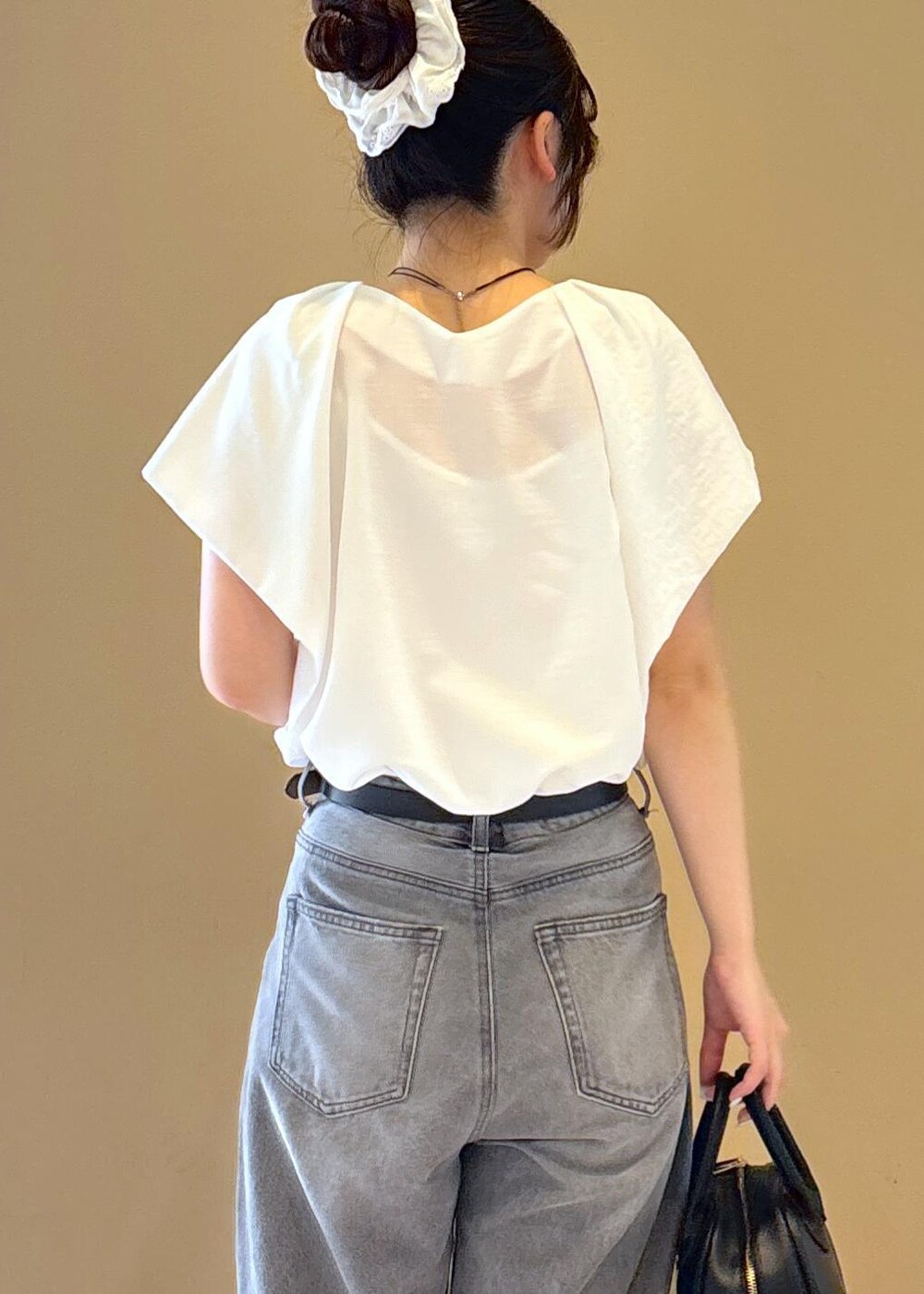 ホワイト系のシャツ/ブラウス、ゴールド系のサンダル、グレー系のデニムパンツを着用したレディースの夏コーディネートの6枚目の写真