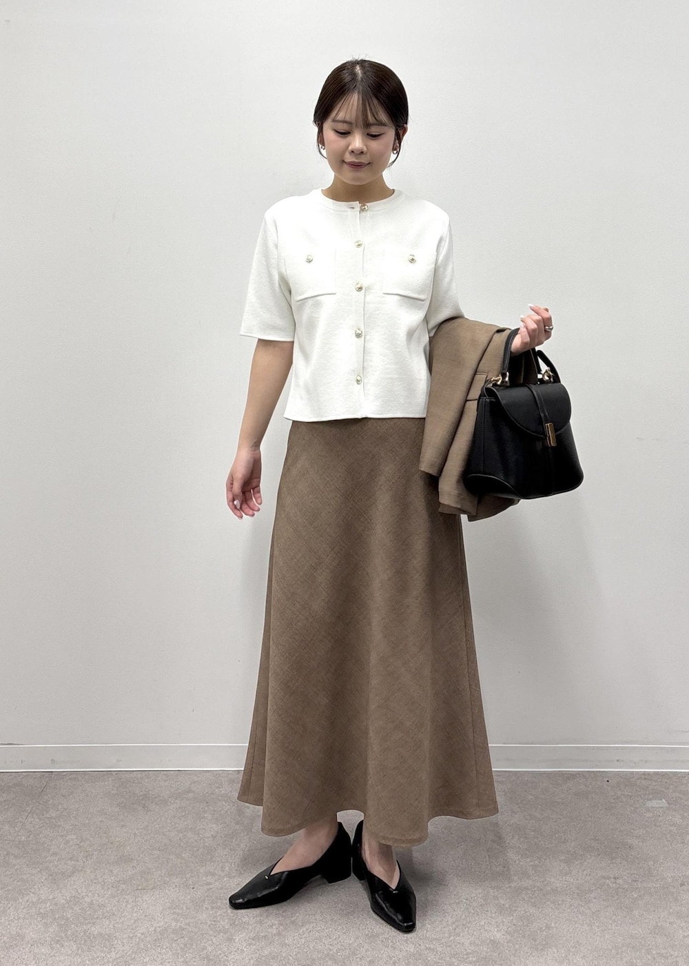 ブラウン系のスカート、ホワイト系のカーディガン/ボレロ、ブラウン系のテーラードジャケットを着用したレディースの春コーディネートの3枚目の写真