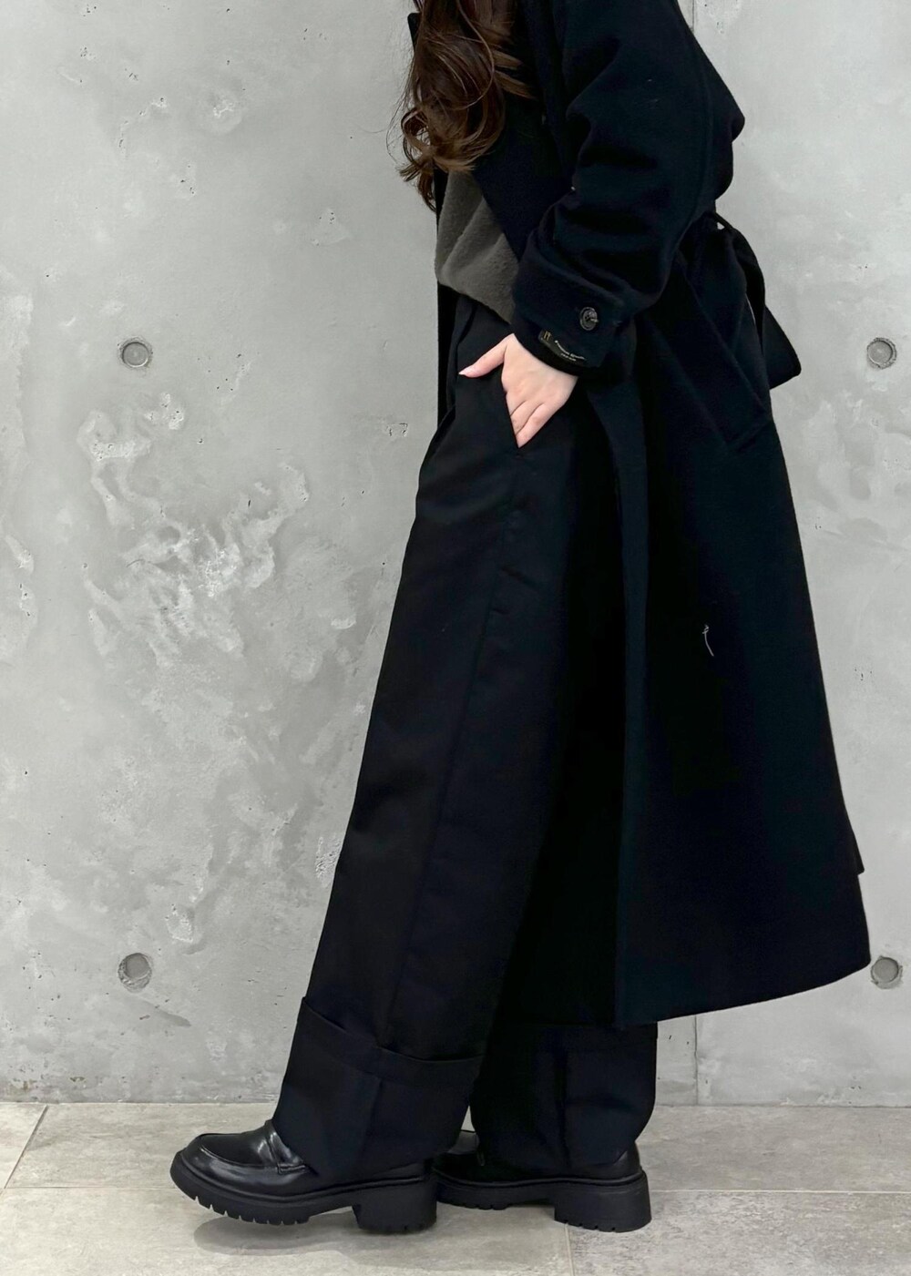 グレー系のニット/セーター、ブラック系のその他アウター、ブラック系のハンドバッグを着用したレディースの冬コーディネートの8枚目の写真