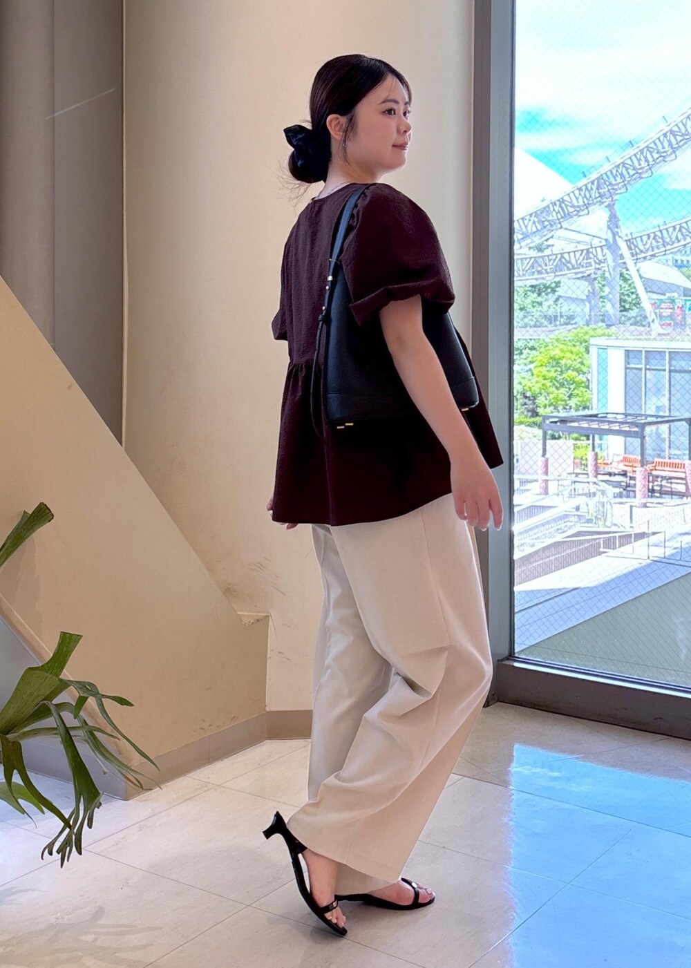ベージュ系のその他パンツ、ブラック系のショルダーバッグ、ブラック系のサンダルを着用したレディースの夏コーディネートの2枚目の写真