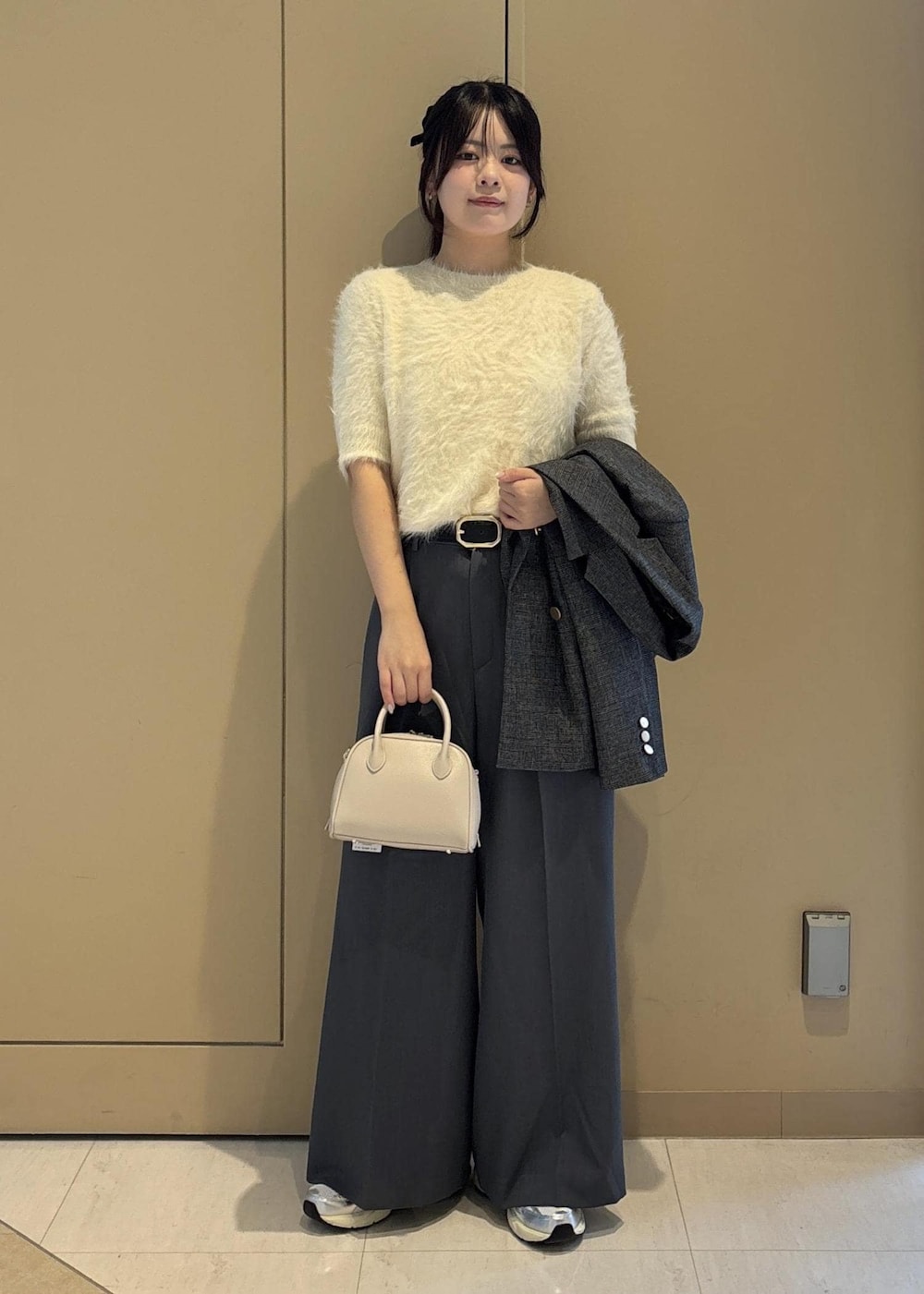 グレー系のテーラードジャケット、ホワイト系のニット/セーター、グレー系のその他パンツを着用したレディースの秋コーディネートの9枚目の写真