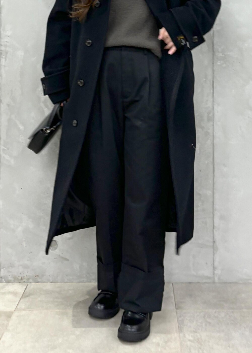 グレー系のニット/セーター、ブラック系のその他アウター、ブラック系のハンドバッグを着用したレディースの冬コーディネートの7枚目の写真