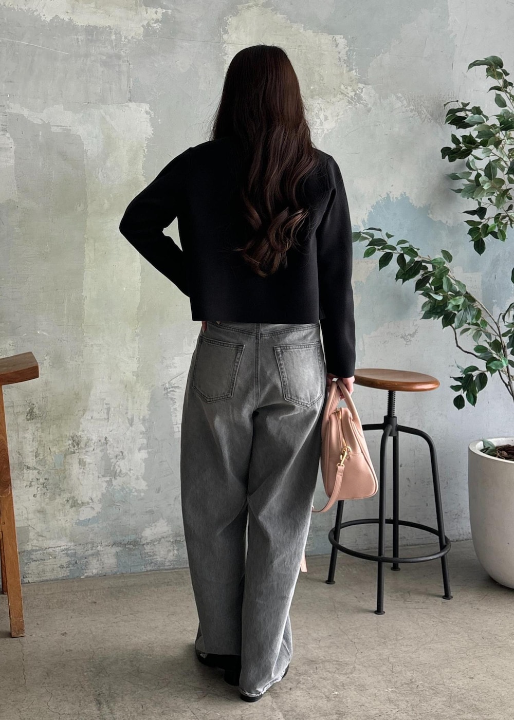 ブラック系のパンプス、グレー系のデニムパンツ、ブラック系のカーディガン/ボレロを着用したレディースの春コーディネートの3枚目の写真