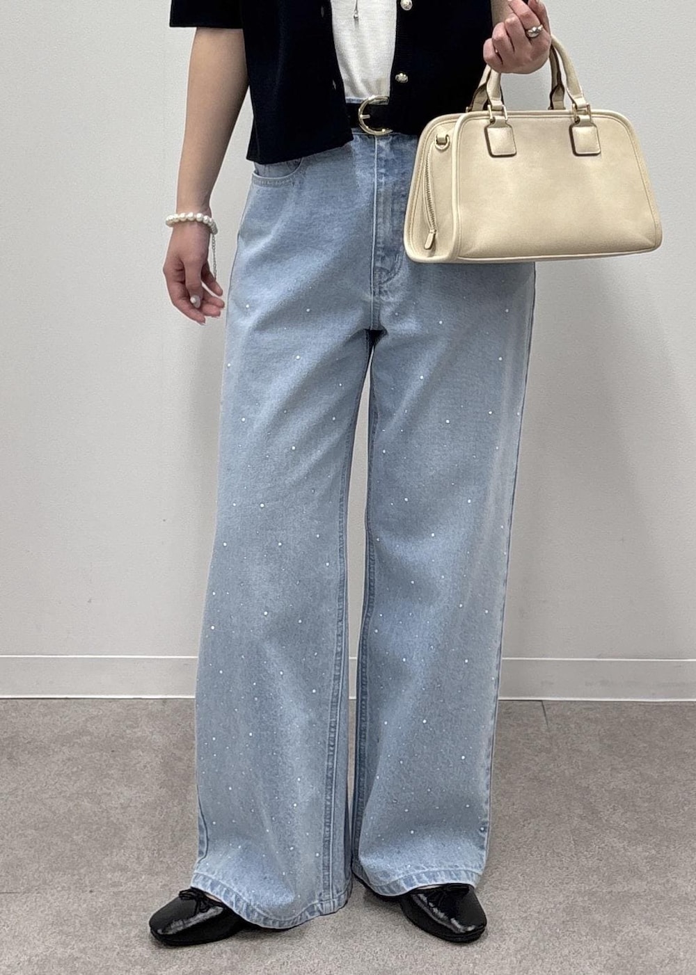 ホワイト系のボストンバッグ、ブルー系のデニムパンツ、ブルー系のカーディガン/ボレロを着用したレディースの春コーディネートの7枚目の写真