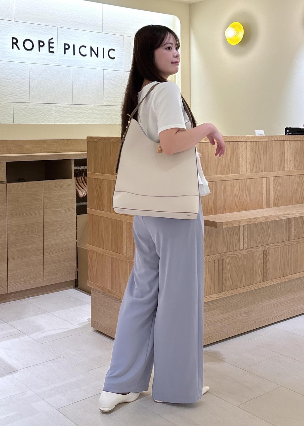 ホワイト系のパンプス、ホワイト系のショルダーバッグ、ホワイト系のTシャツ/カットソーを着用したレディースの夏コーディネートの2枚目の写真