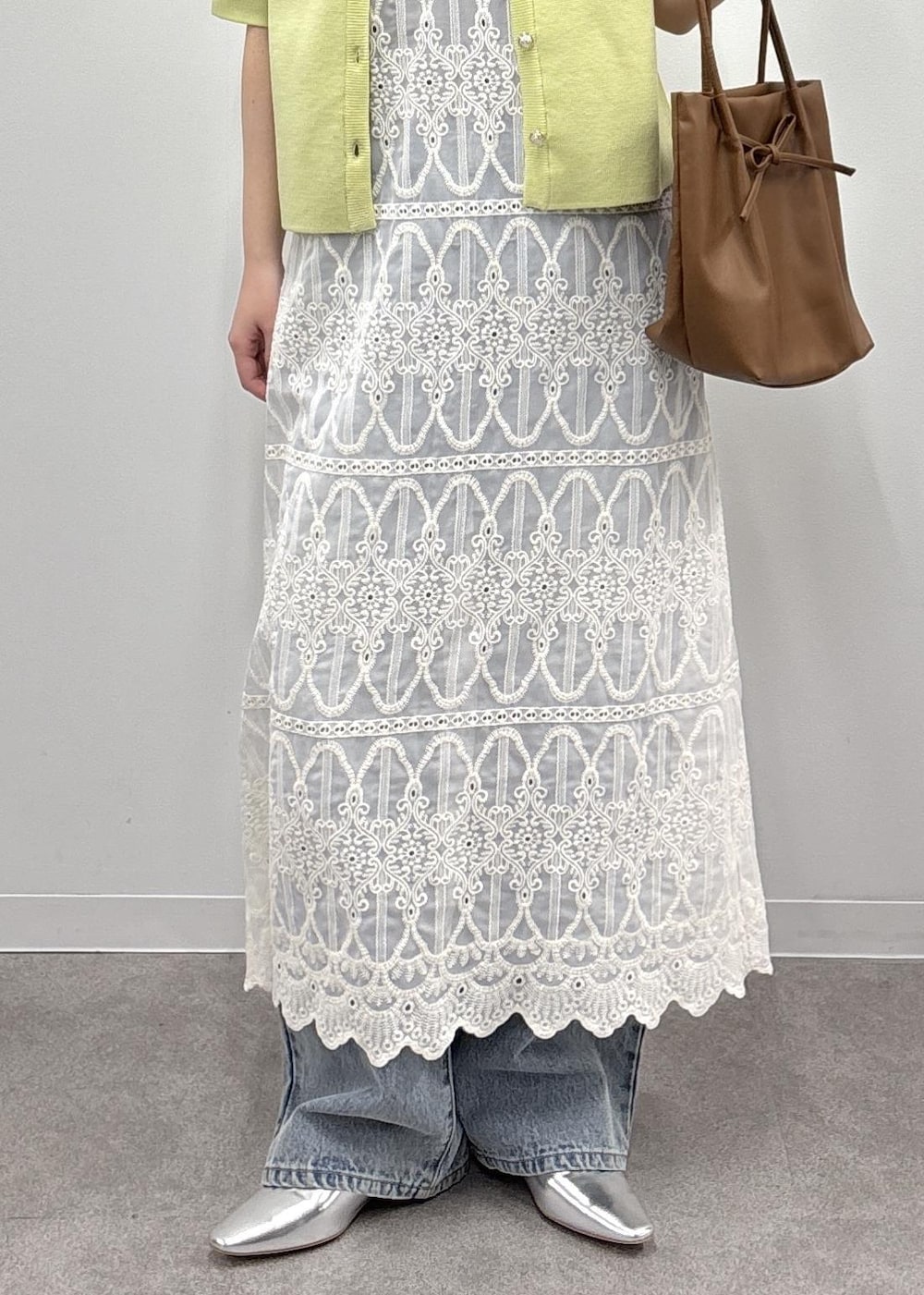 ホワイト系のワンピース、ブラウン系のタンクトップ、グリーン系のカーディガン/ボレロを着用したレディースの春コーディネートの7枚目の写真