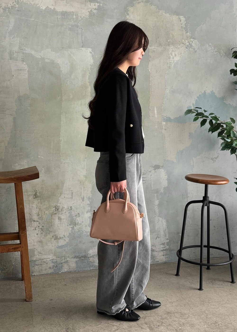 ブラック系のパンプス、グレー系のデニムパンツ、ブラック系のカーディガン/ボレロを着用したレディースの春コーディネートの2枚目の写真