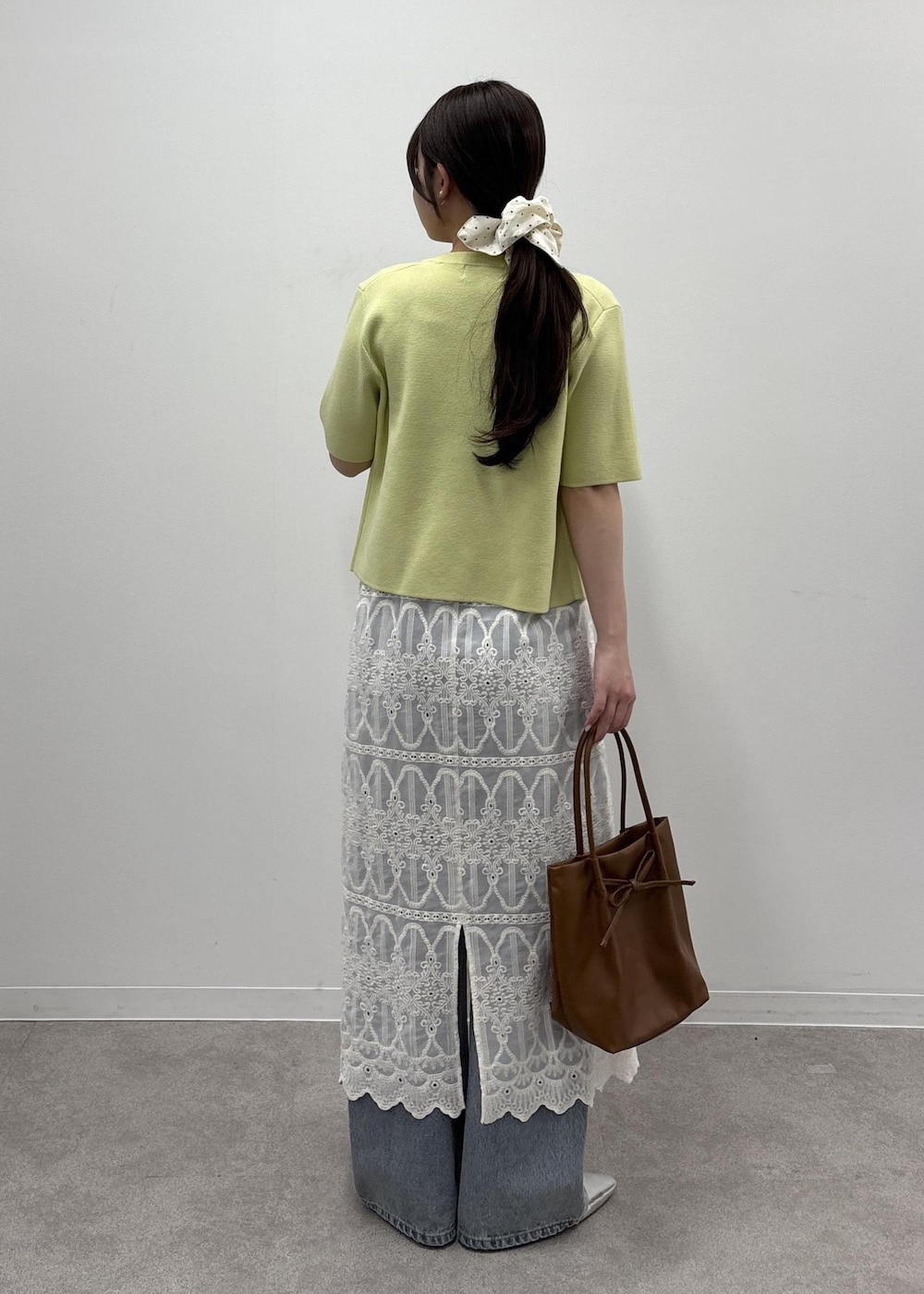 ホワイト系のワンピース、ブラウン系のタンクトップ、グリーン系のカーディガン/ボレロを着用したレディースの春コーディネートの3枚目の写真