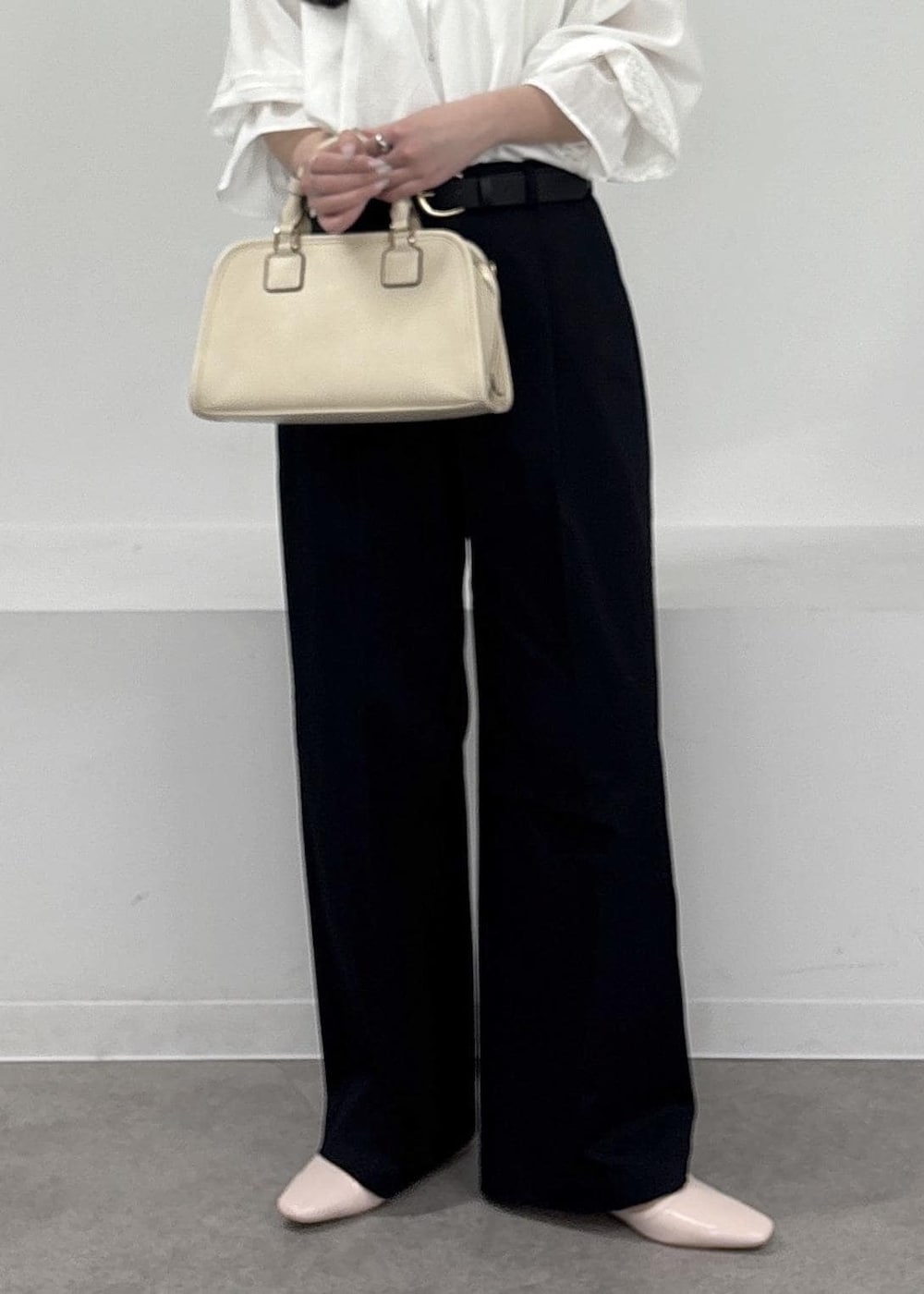 ホワイト系のボストンバッグ、ブルー系のチノパンツ、ピンク系のパンプスを着用したレディースの春コーディネートの6枚目の写真