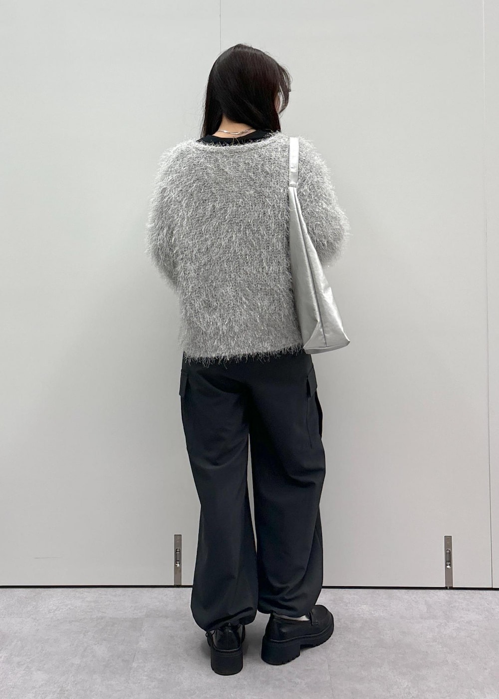 ブラック系のローファー、シルバー系のトートバッグ、グレー系のカーディガン/ボレロを着用したレディースの秋コーディネートの3枚目の写真