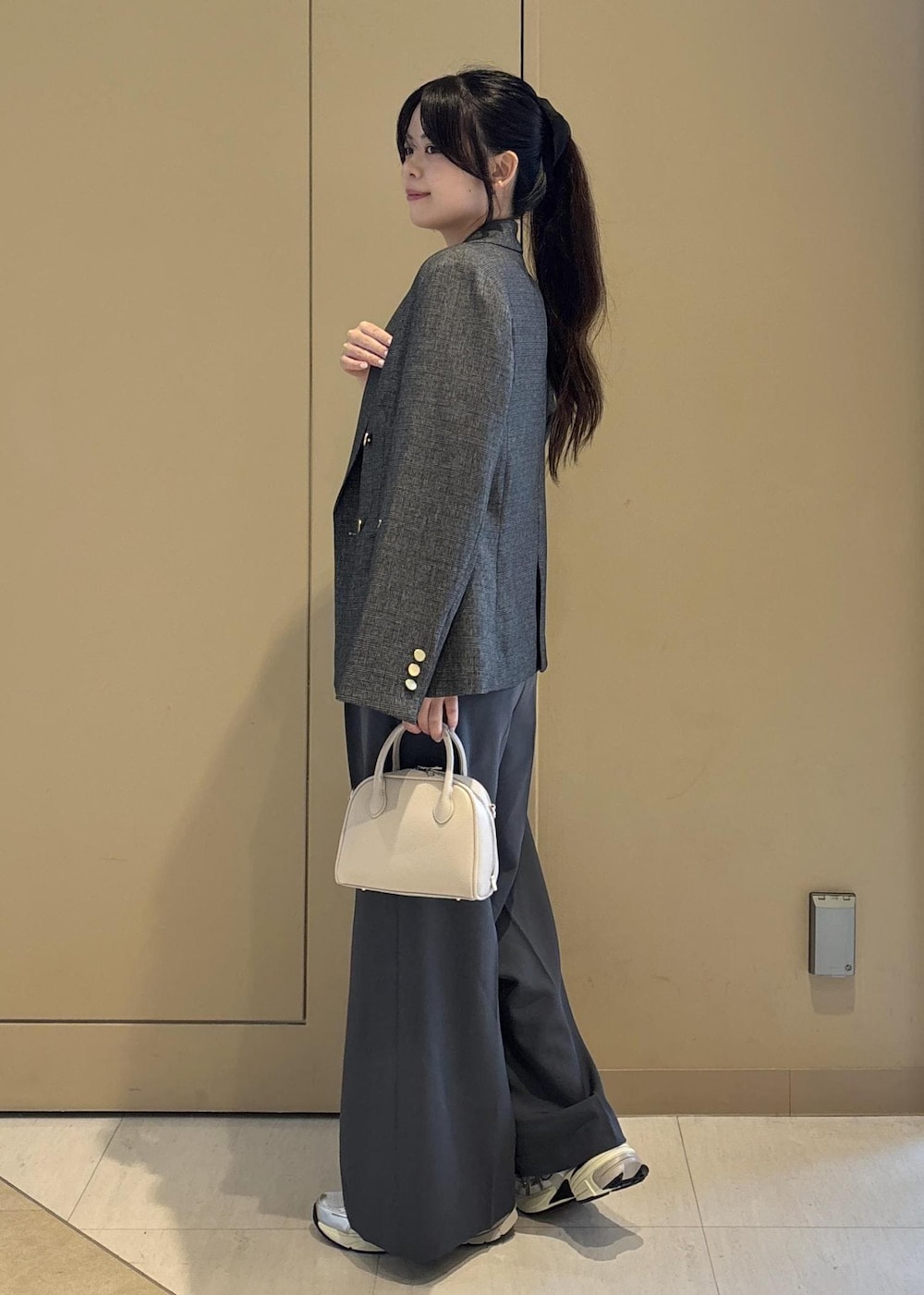 グレー系のテーラードジャケット、ホワイト系のニット/セーター、グレー系のその他パンツを着用したレディースの秋コーディネートの2枚目の写真