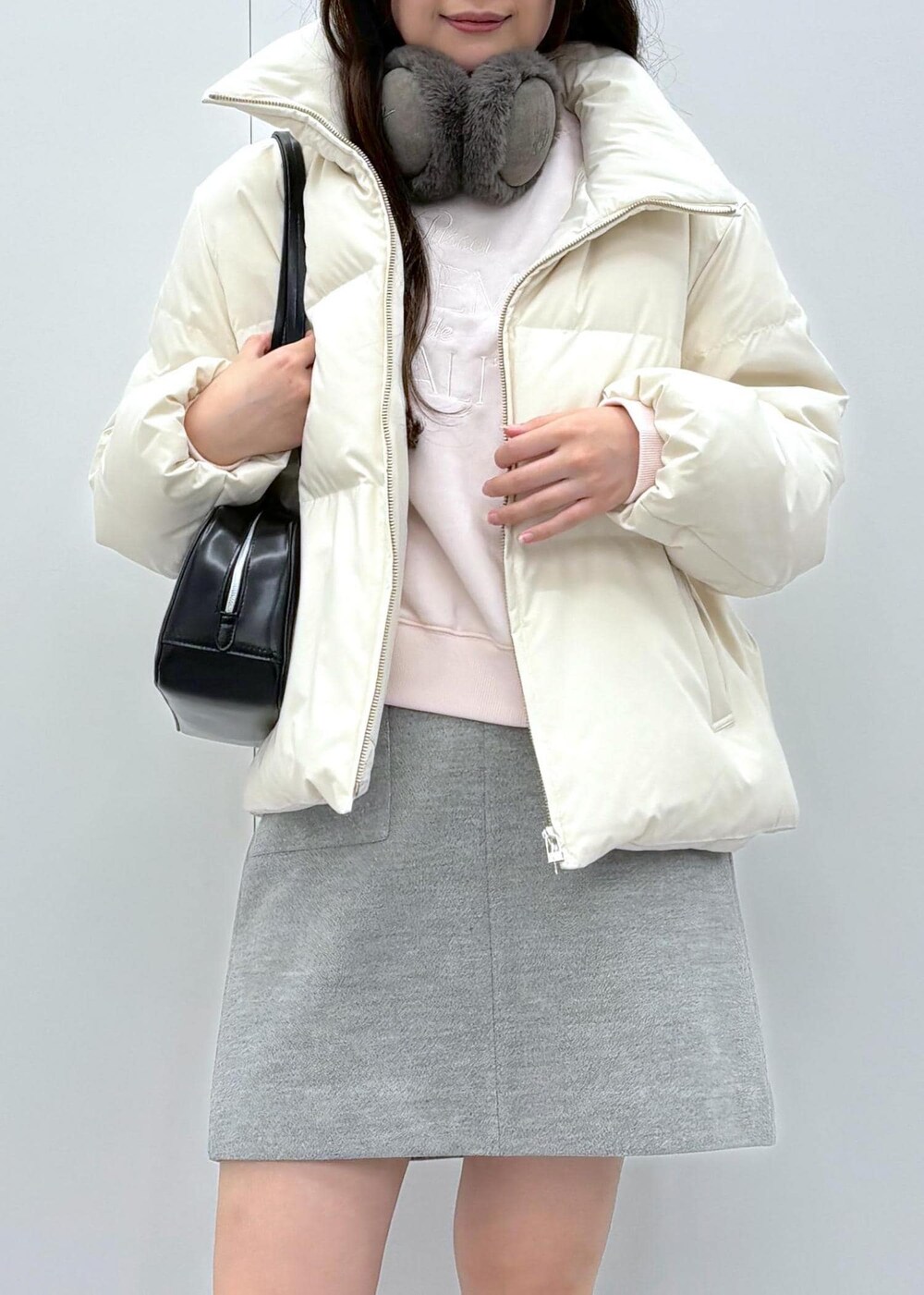 ブラック系のブーツ、ベージュ系のダウンジャケット/コート、ブラック系のボストンバッグを着用したレディースの秋コーディネートの5枚目の写真