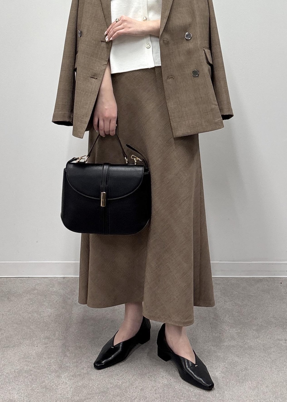 ブラウン系のスカート、ホワイト系のカーディガン/ボレロ、ブラウン系のテーラードジャケットを着用したレディースの春コーディネートの6枚目の写真