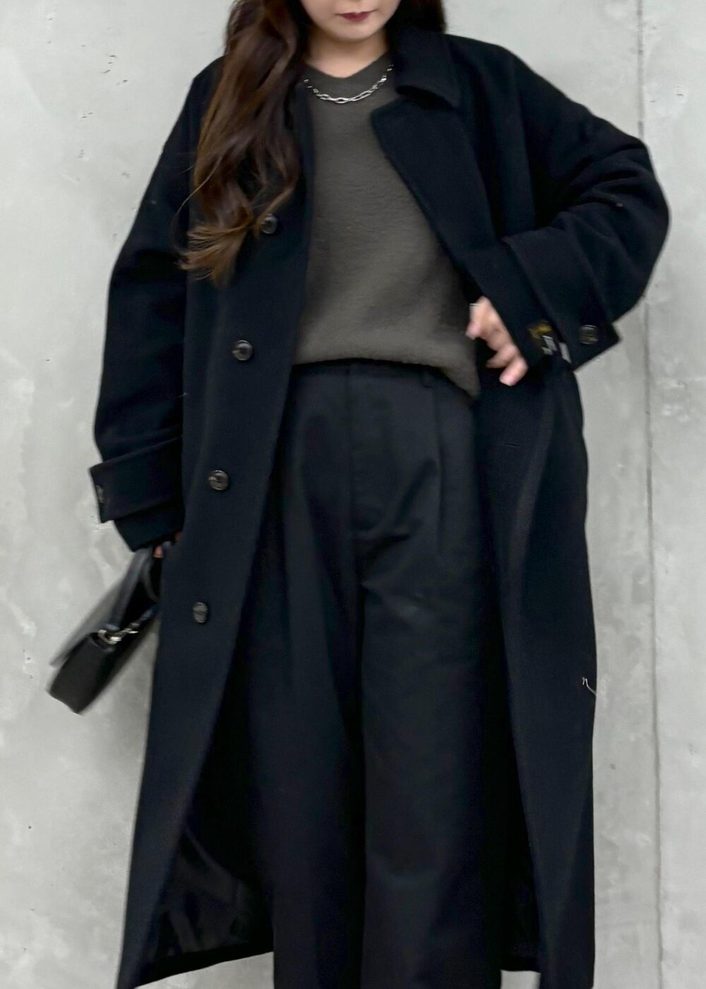 グレー系のニット/セーター、ブラック系のその他アウター、ブラック系のハンドバッグを着用したレディースの冬コーディネートの5枚目の写真