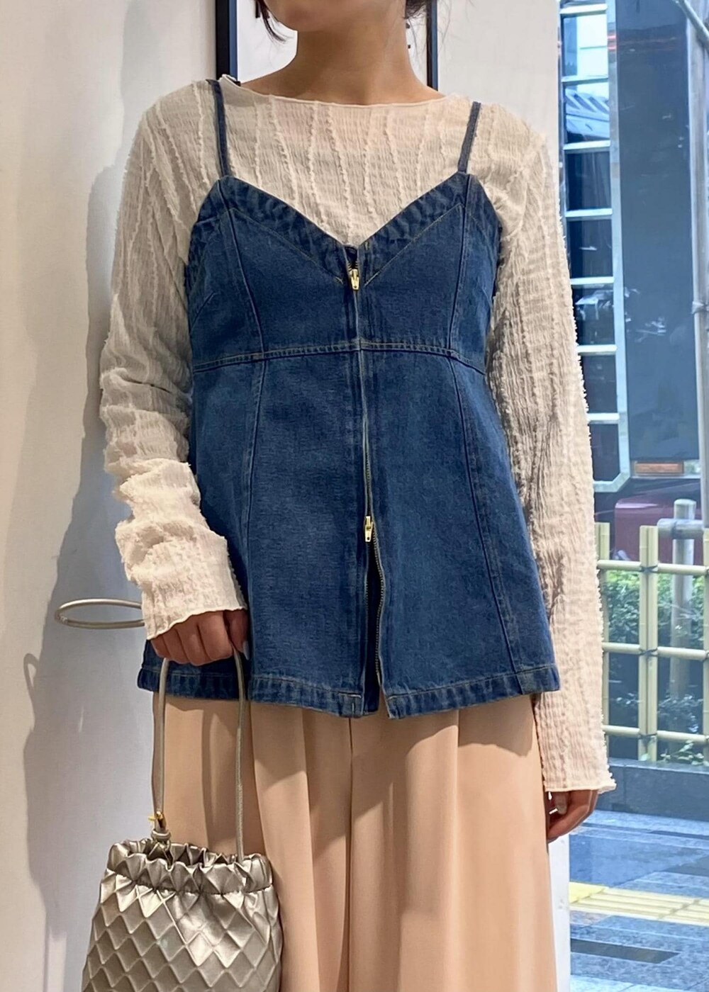 シルバー系のパンプス、ホワイト系のTシャツ/カットソー、シルバー系のショルダーバッグを着用したレディースの春コーディネートの3枚目の写真