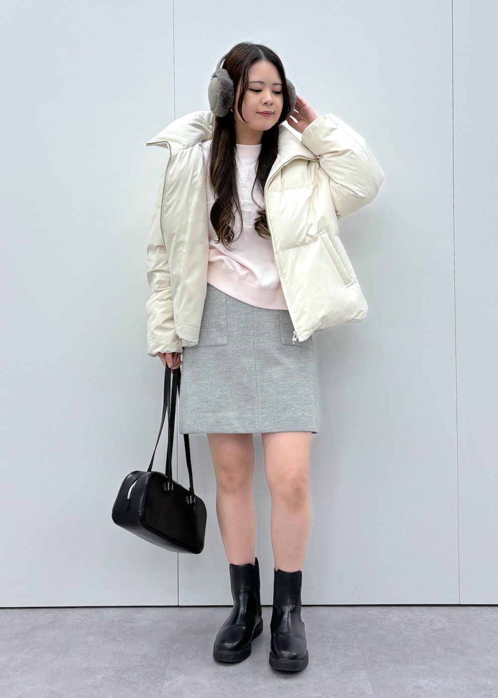 ブラック系のブーツ、ベージュ系のダウンジャケット/コート、ブラック系のボストンバッグを着用したレディースの秋コーディネートの4枚目の写真