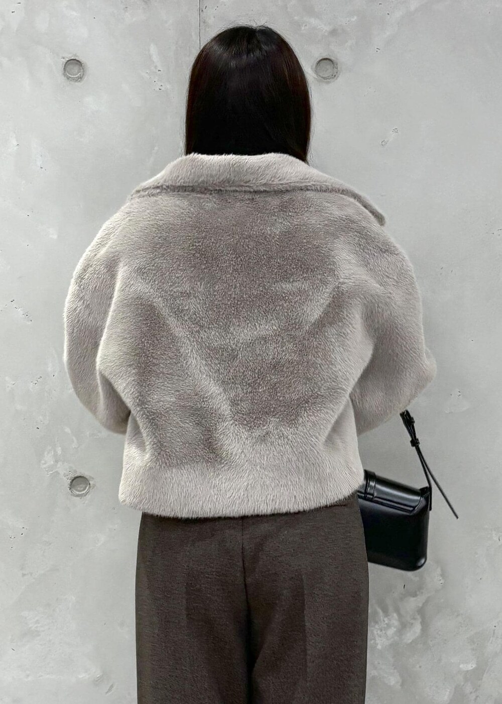 ブラウン系のブルゾン、ブラック系のニット/セーター、ブラウン系のその他パンツを着用したレディースの冬コーディネートの6枚目の写真