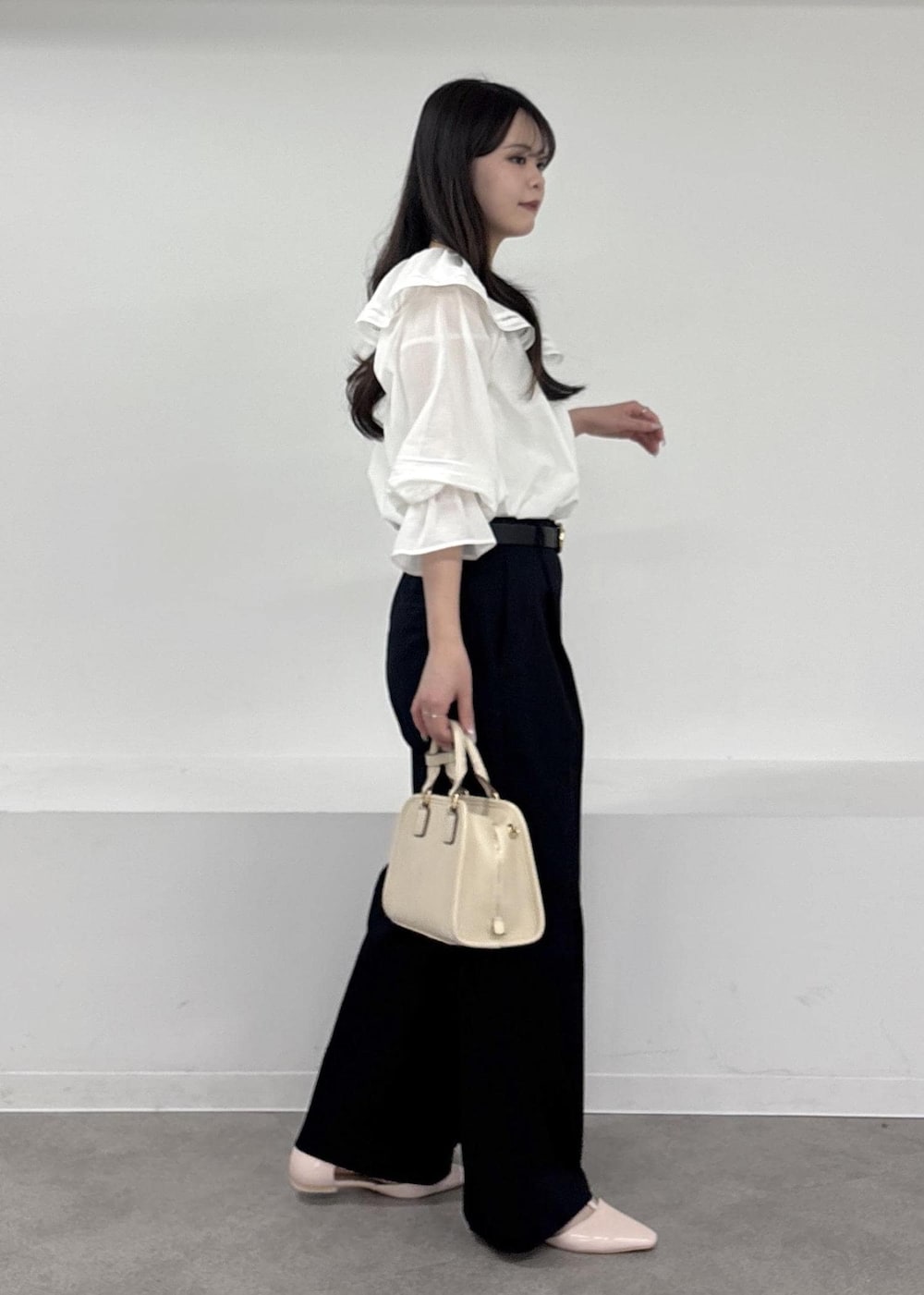 ホワイト系のボストンバッグ、ブルー系のチノパンツ、ピンク系のパンプスを着用したレディースの春コーディネートの2枚目の写真