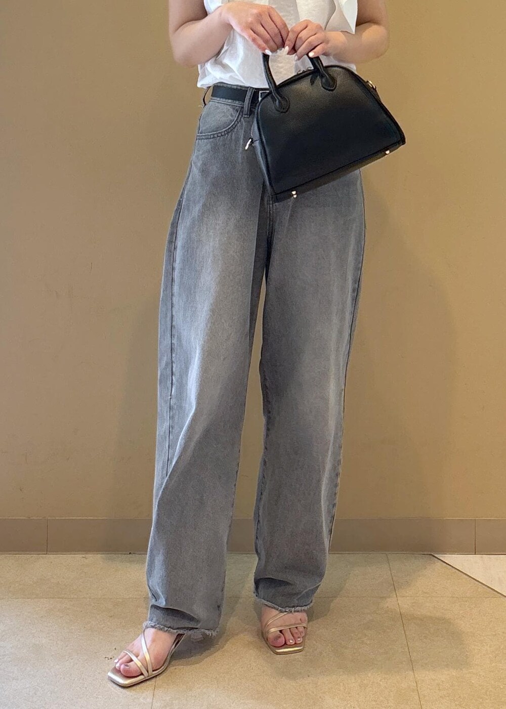 ホワイト系のシャツ/ブラウス、ゴールド系のサンダル、グレー系のデニムパンツを着用したレディースの夏コーディネートの7枚目の写真