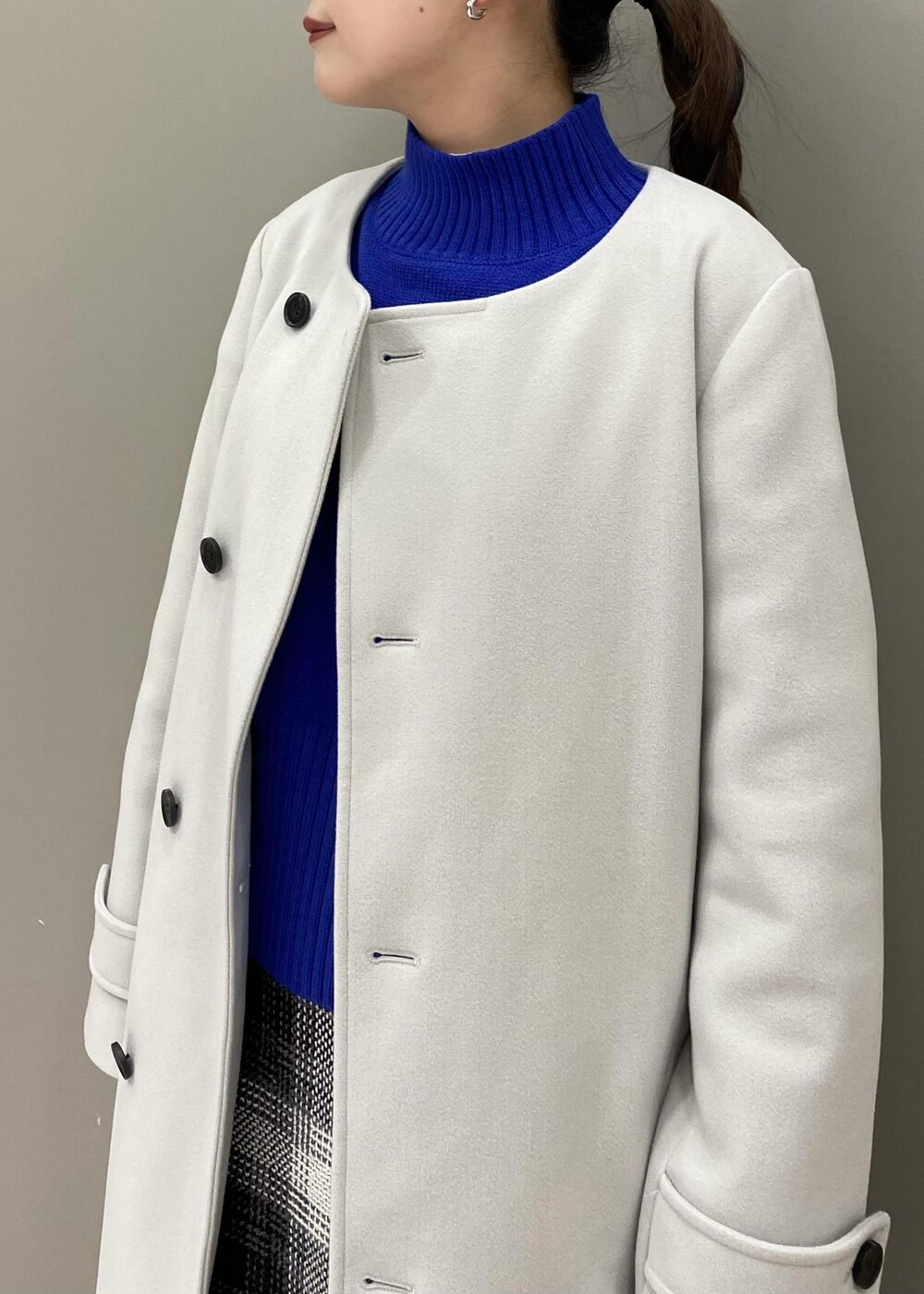 ブルー系のニット/セーター、ブラック系のショルダーバッグ、ブラック系のブーツを着用したレディースの秋コーディネートの3枚目の写真